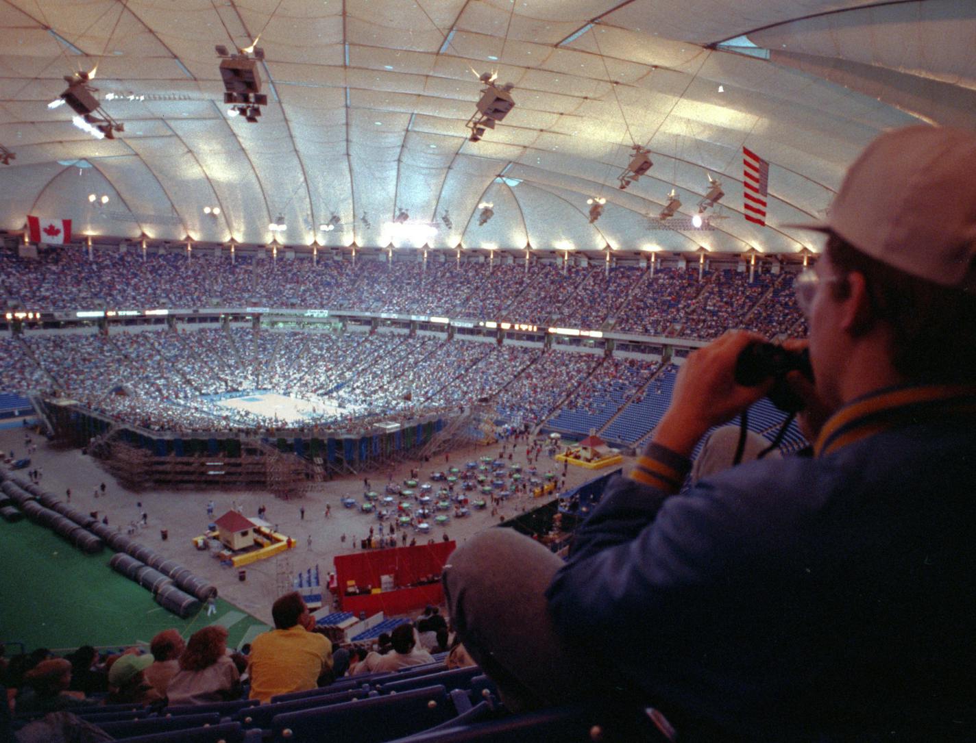 Erik Gafkjen, of Columbia Heights, uses binoculars to watch the Minnesota Timberwolves play the Denver Nuggets at the Metrodome on April 17, 1990. (Brian Peterson/Star Tribune)