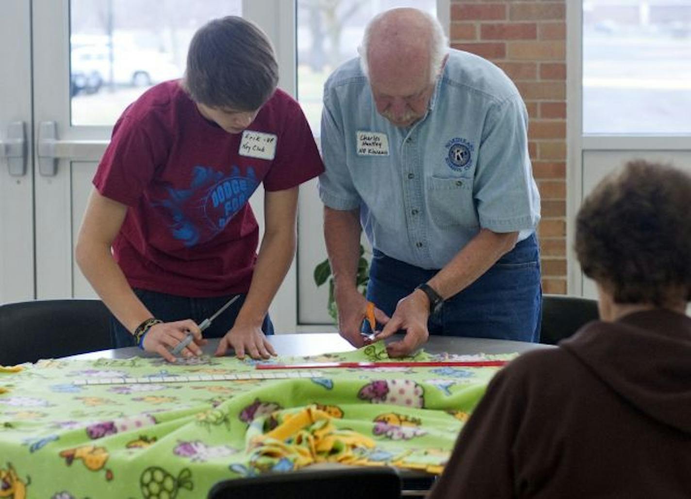 As part of the Kiwanis Club's focus on youth, member Charles of Huntley of Hudson, Wis., worked with Fridley 10th-grader Erik Keeler at a blanket-tying event.