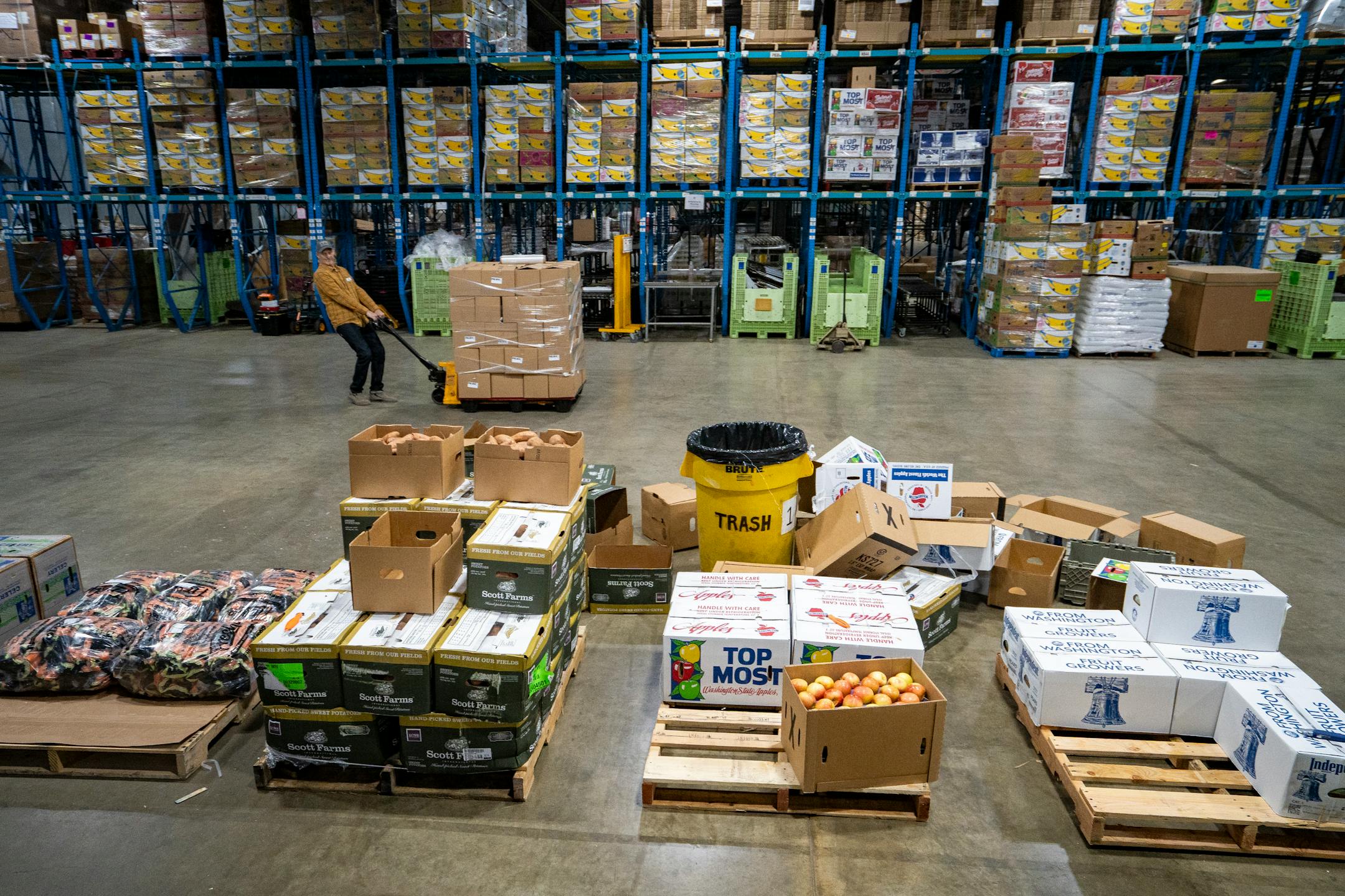 A volunteer hauls the Food Group's first full pallet of produce boxes during the food bank's "Pack to the Max" event.