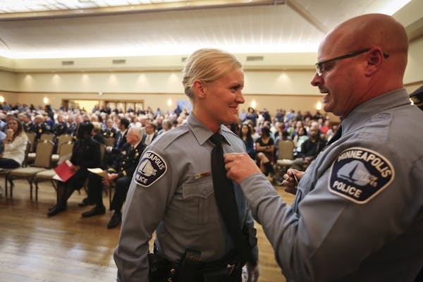 Minneapolis police officer Mike Osbeck pinned a badge on his daughter Angela Osbeck during a Minneapolis Police Department swearing in ceremony in Min