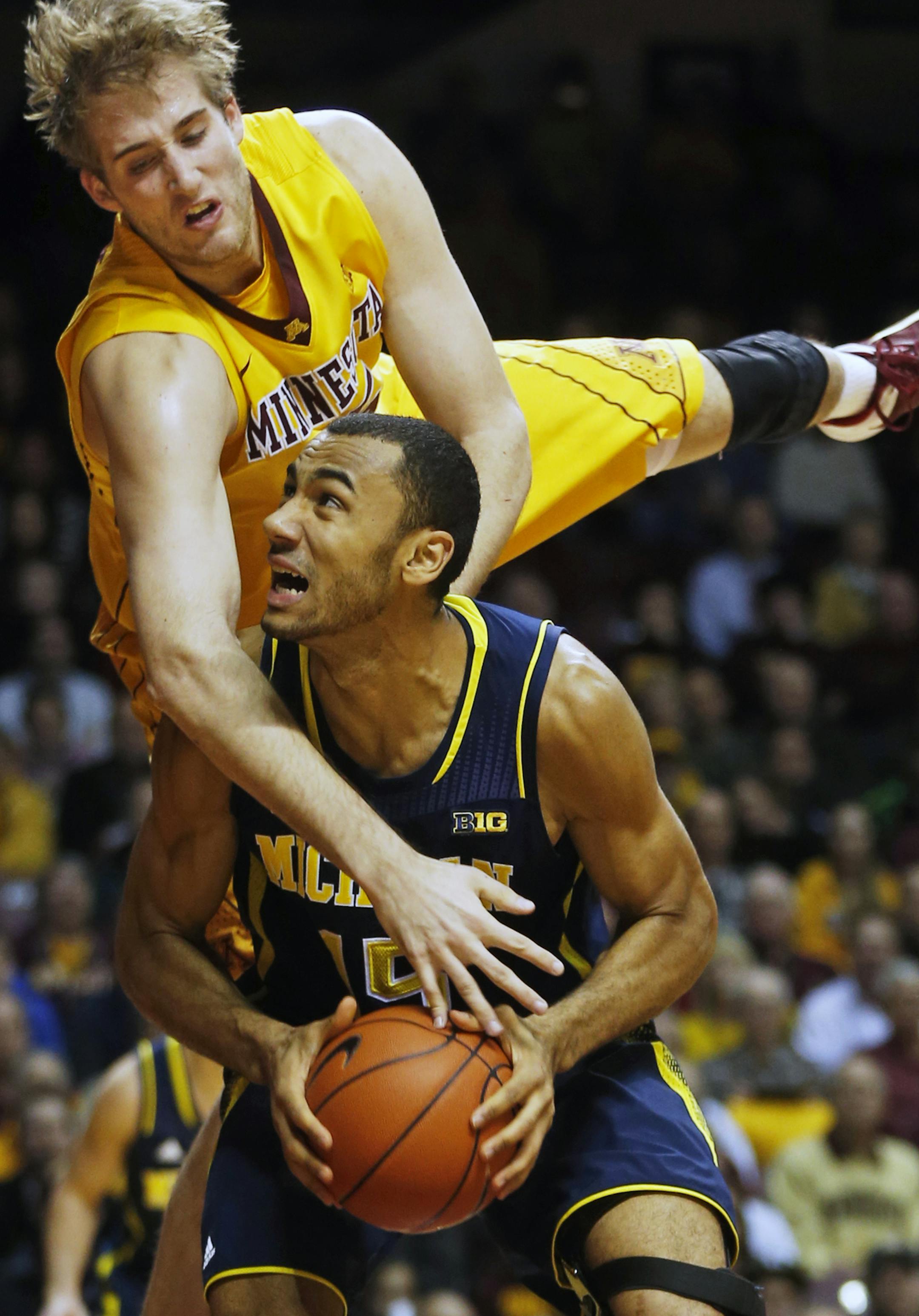Gophers center Elliott Eliason came down on top of Michigan&#x2019;s Jon Horford for a foul as Horford attempted to score in the first half.