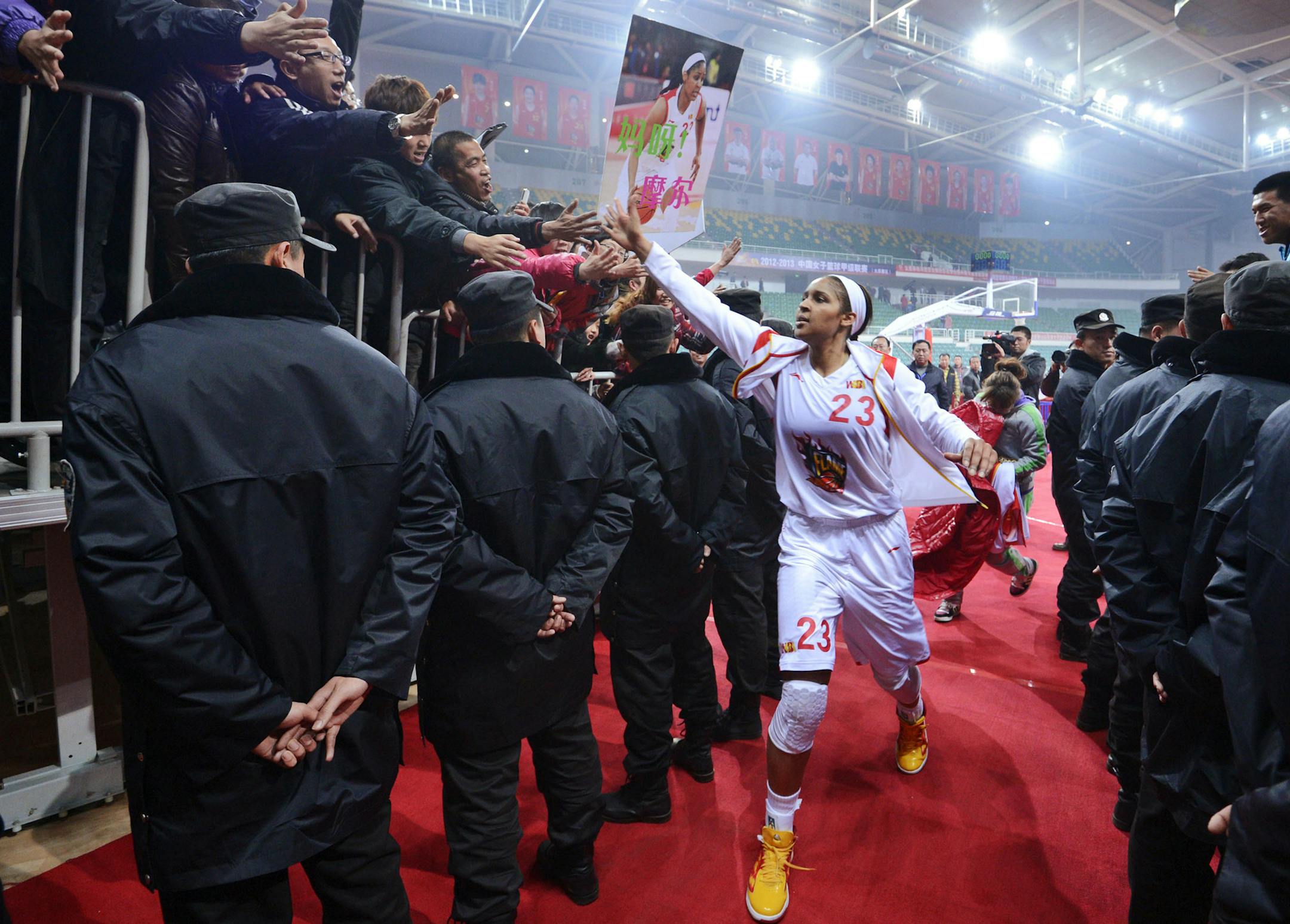 In this Nov. 24, 2012, photo, Shanxi Flame's Maya Moore greets fans as she prepares to take the court for a WCBA basketball game against the Jiangsu Dragons in Taiyuan, China. While her Minnesota Lynx team awaits the return of WNBA training camp in May, Moore is averaging 45 points a game and earning mid-six figures for the Flame, helping bring new fans to the women's game in a baseball crazed nation. (AP Photo/CHINATOPIX) CHINA OUT ORG XMIT: XAY802