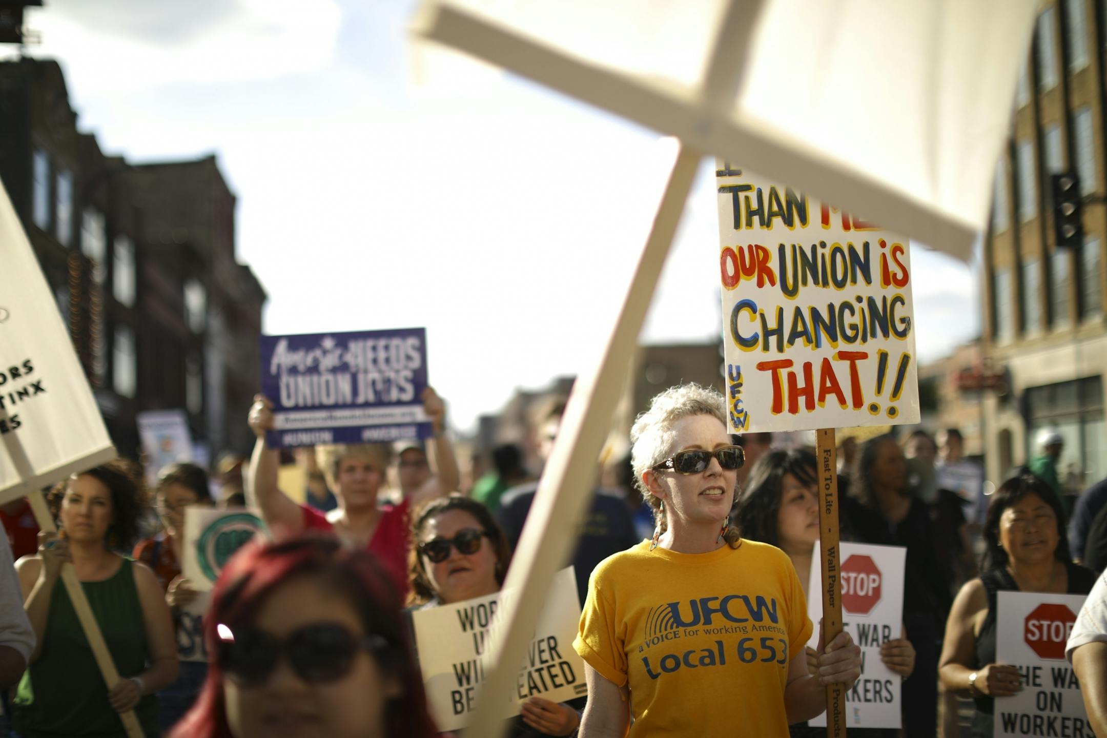 The union workers and their supporters, including Amy Swenson, in the yellow shirt, chanted slogans as they marched on Washington Ave. to the U.S. Federal Courthouse. She's leading an effort to unionize employees at the Seward Co-op.