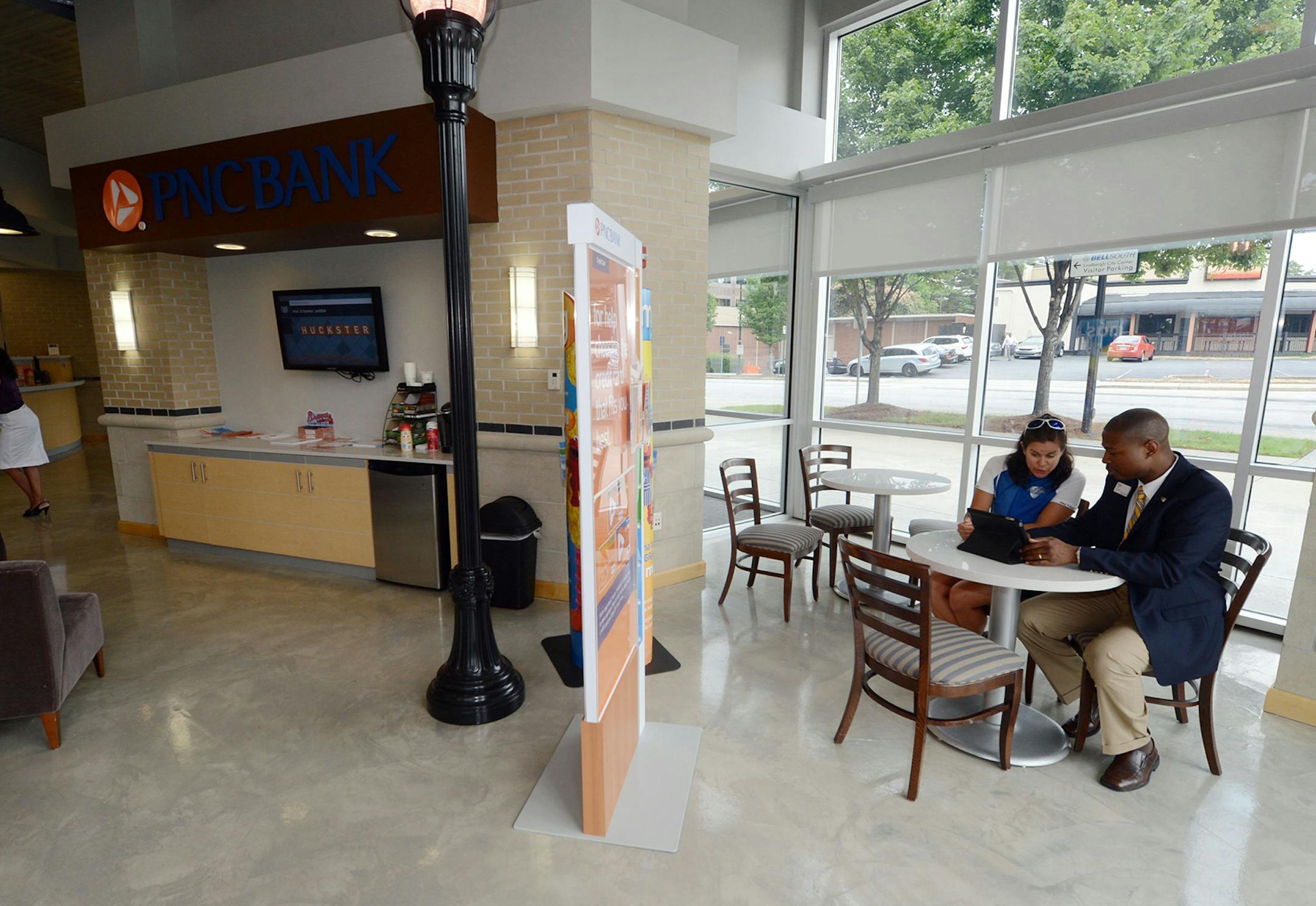Keith Hardy, a branch manager at PNC bank, shows customer Mari Fridenmaker details on accounts by using an iPad in Atlanta, Georgia, on June 27, 2013. Though more people are doing their banking electronically, they cite easy access to a local branch and a key factor in choosing a bank. (Kent D. Johnson/Atlanta Journal-Constitution/MCT) ORG XMIT: 1140747