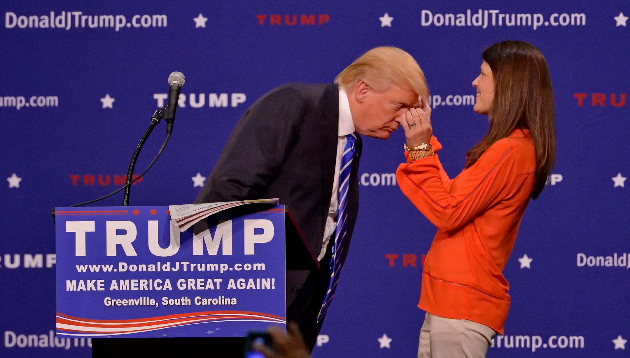 Republican presidential candidate Donald Trump has a supporter, Mary Margaret Bannister, check to see if his hair is real during his speech to supporters during a rally at the TD Convention Center, Thursday, Aug. 27, 2015, in Greenville, S.C. (AP Photo/Richard Shiro)