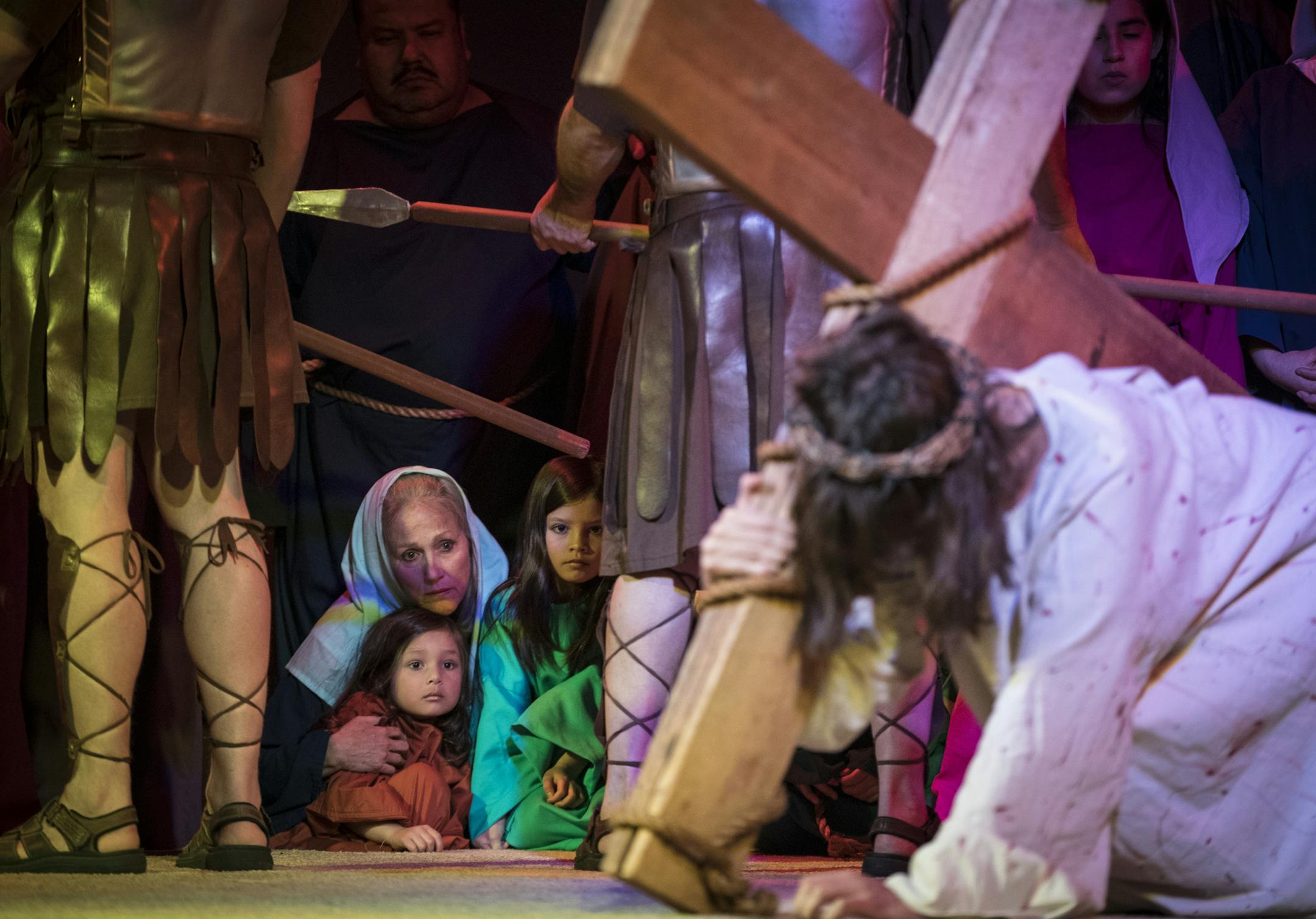Robin Goblish huddled with Therese Kane and Coleen Kane as they watched Jesus, played by Father Erik Lundgren, struggle with the cross during a dress rehearsal of a scene in The Passion of Jesus in Music, Word and Light at Saint Mark's Church in Shakopee, Minn., on Wednesday, March 7, 2018. ] RENEE JONES SCHNEIDER • renee.jones@startribune.com