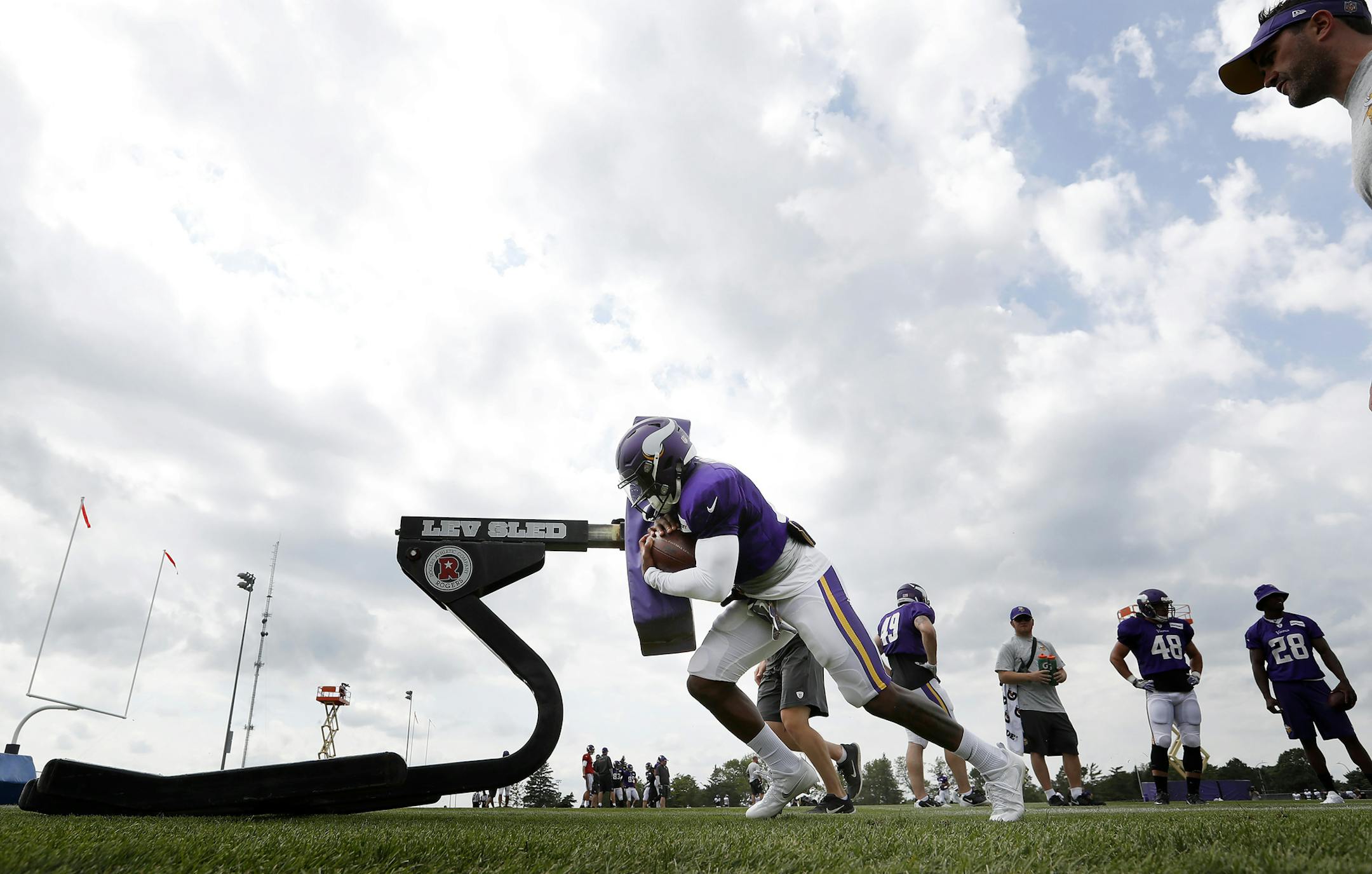 Vikings running back Jerick McKinnon (21) hit the sled during an afternoon workout last summer.