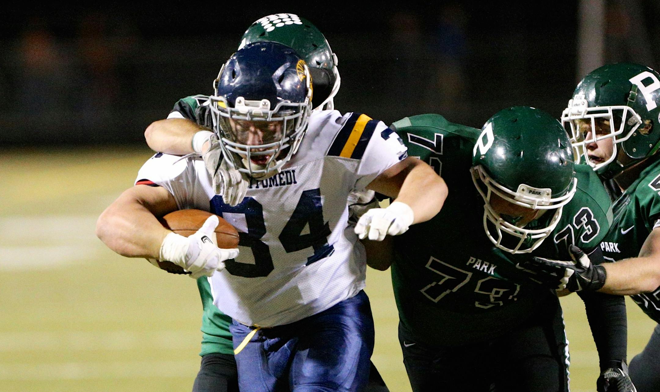 Mahtomedil senior running back T.J. Tumbleson (#34) shakes off several Park of Cottage Grove defenders for a first down.