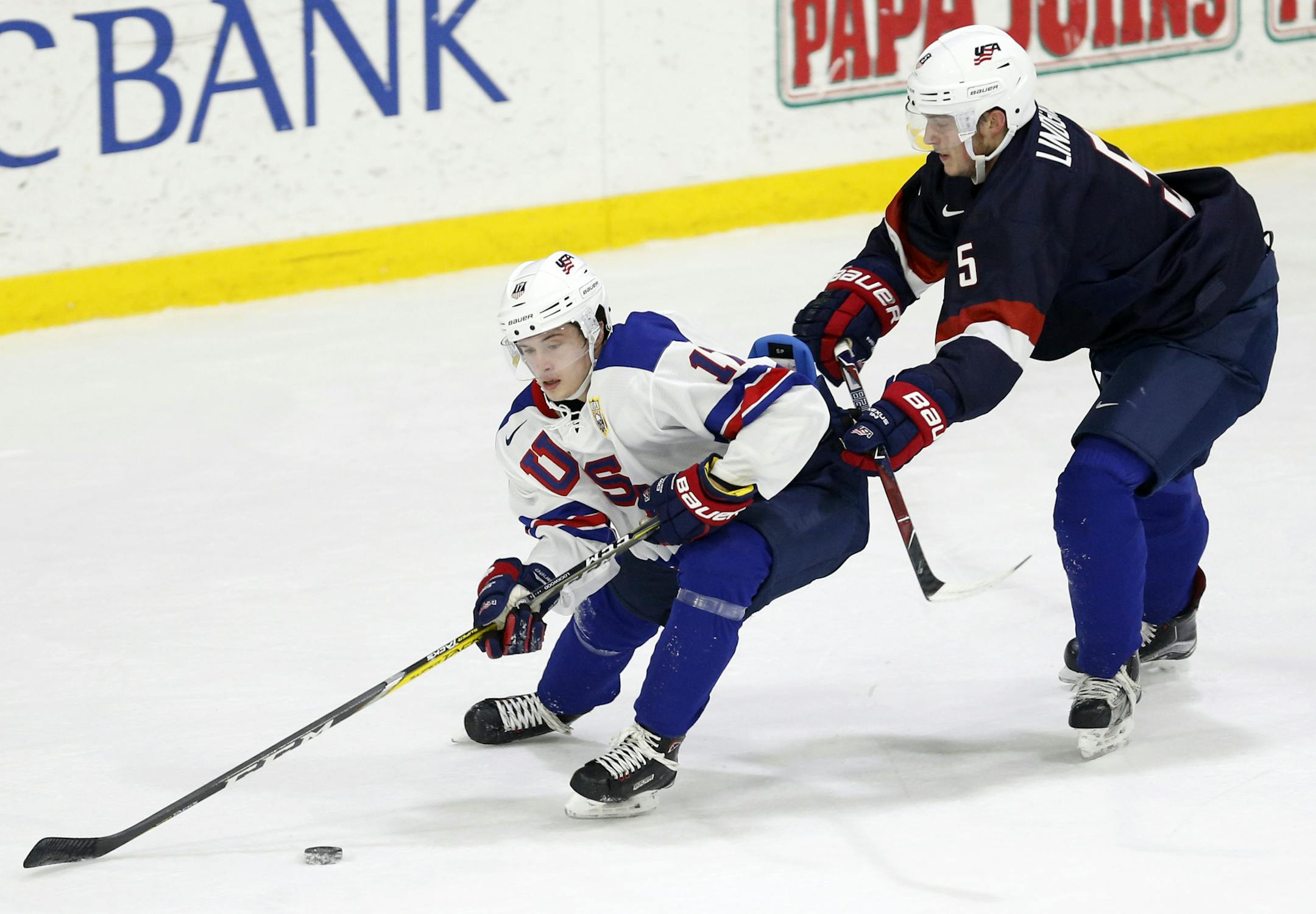 In this Sunday, Dec. 17, 2017 photo, United States' Ryan Lindgren, right, checks Kailer Yamamoto during hockey practice in Columbus, Ohio. Expectations will be high when the US under-20 team defends its title on home soil at the World Junior tournament, starting the day after Christmas in Buffalo, N.Y. (AP Photo/Jay LaPrete)