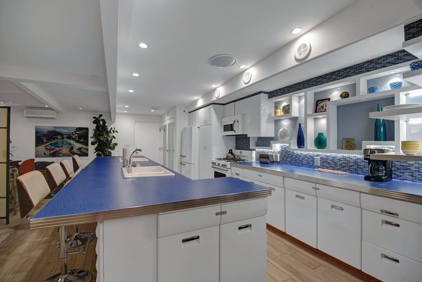 A photo provided by James Butchart, shows the renovated kitchen in Palm Springs, Calif., of Molly Evans who installed an electric-blue Formica countertop and retro-style appliances that she bought from Home Depot, finishing the look with a set of swivel counter stools with wood laminate backs. (James Butchart via The New York Times) — NO SALES; FOR EDITORIAL USE ONLY WITH NYT STORY HOME-RENOVATION-KITSCH BY RONDA KAYSEN FOR NOV. 18, 2021. ALL OTHER USE PROHIBITED. —