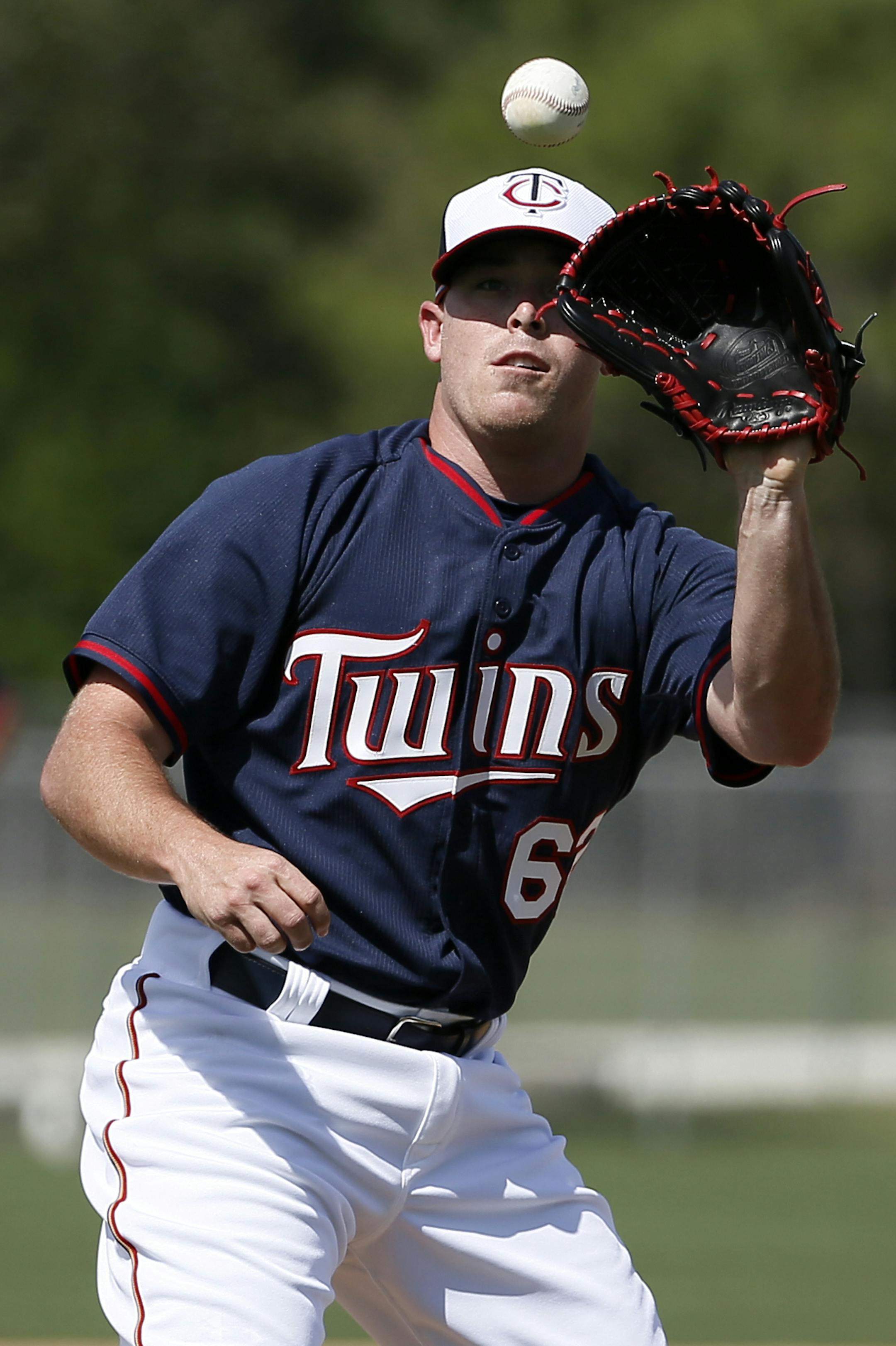 Minnesota Twins' J.R. Graham (62) fields a ground ball back to the mound during infield drills at baseball spring training in Fort Myers, Fla., Tuesday March 3, 2015. (AP Photo/Tony Gutierrez) ORG XMIT: MIN2015040119281782