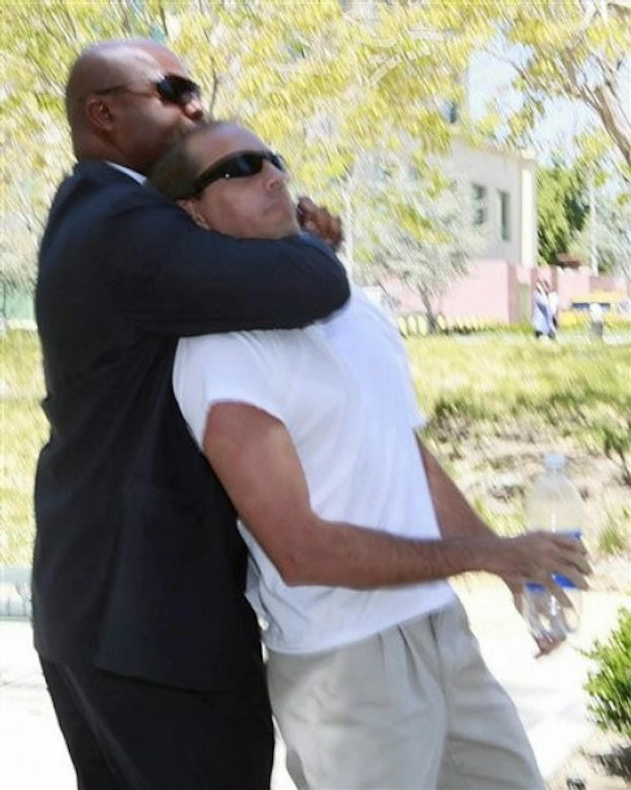 One of Paris Hilton's bodyguards, left, restrains an unidentified assailant after the man grabbed Paris Hilton's boyfriend Cy Waits as Waits and Hilton were walking into court Wednesday April 27, 2011 in Los Angeles. The assailant was detained by police. (AP Photo/Nick Ut)