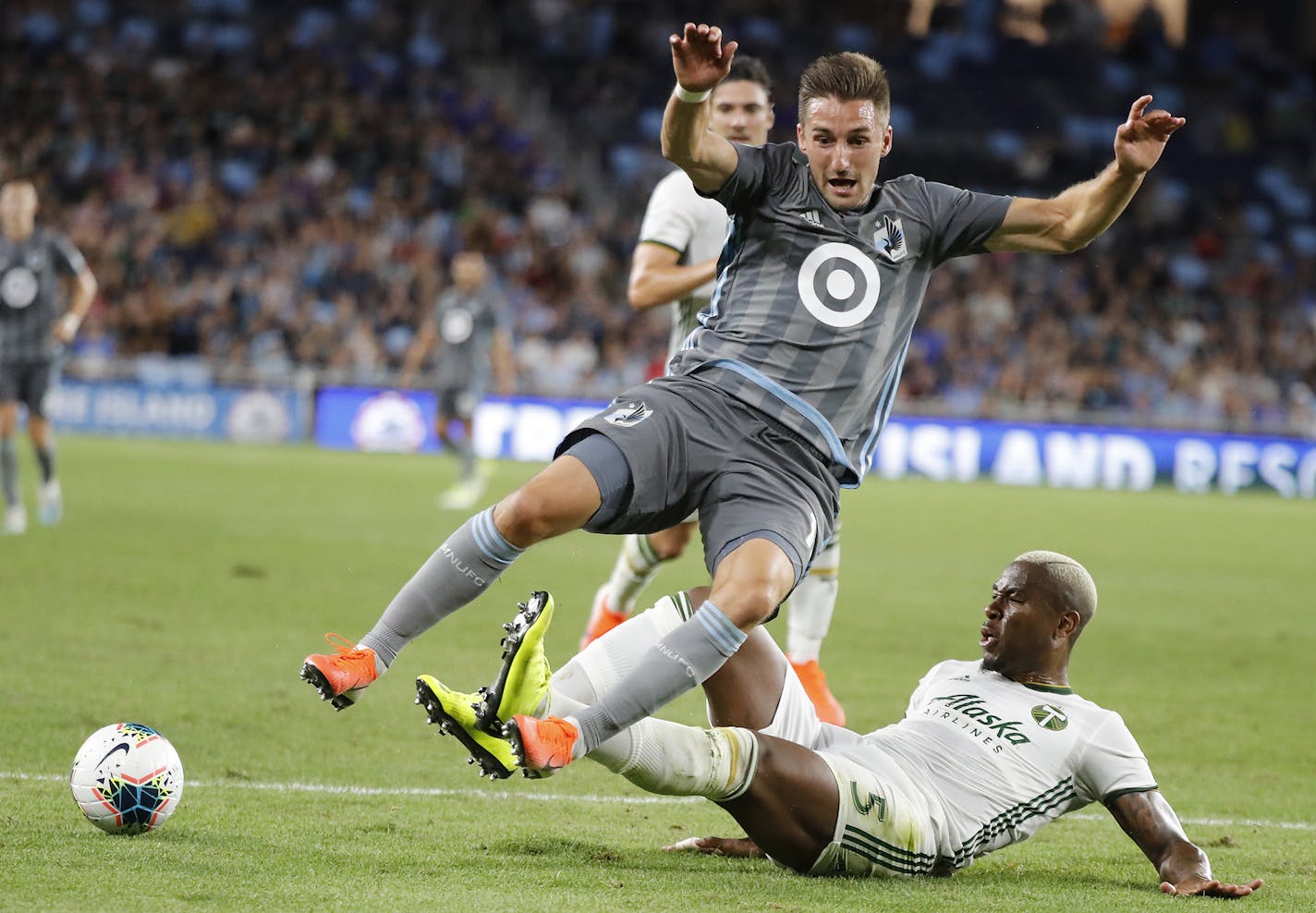 Minnesota United midfielder Ethan Finlay (13) tripped as Portland Timbers defender Claude Dielna (5) slides under him during the second half. ] LEILA NAVIDI • leila.navidi@startribune.com BACKGROUND INFORMATION: The U.S. Open Cup semifinals between the Minnesota United and the Portland Timbers at Allianz Field in St. Paul on Wednesday, August 7, 2019. Minnesota United won the game 2-1.