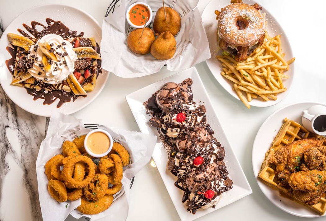 An assortment of dishes from Sugar Factory, including the Donut Burger (top right).
