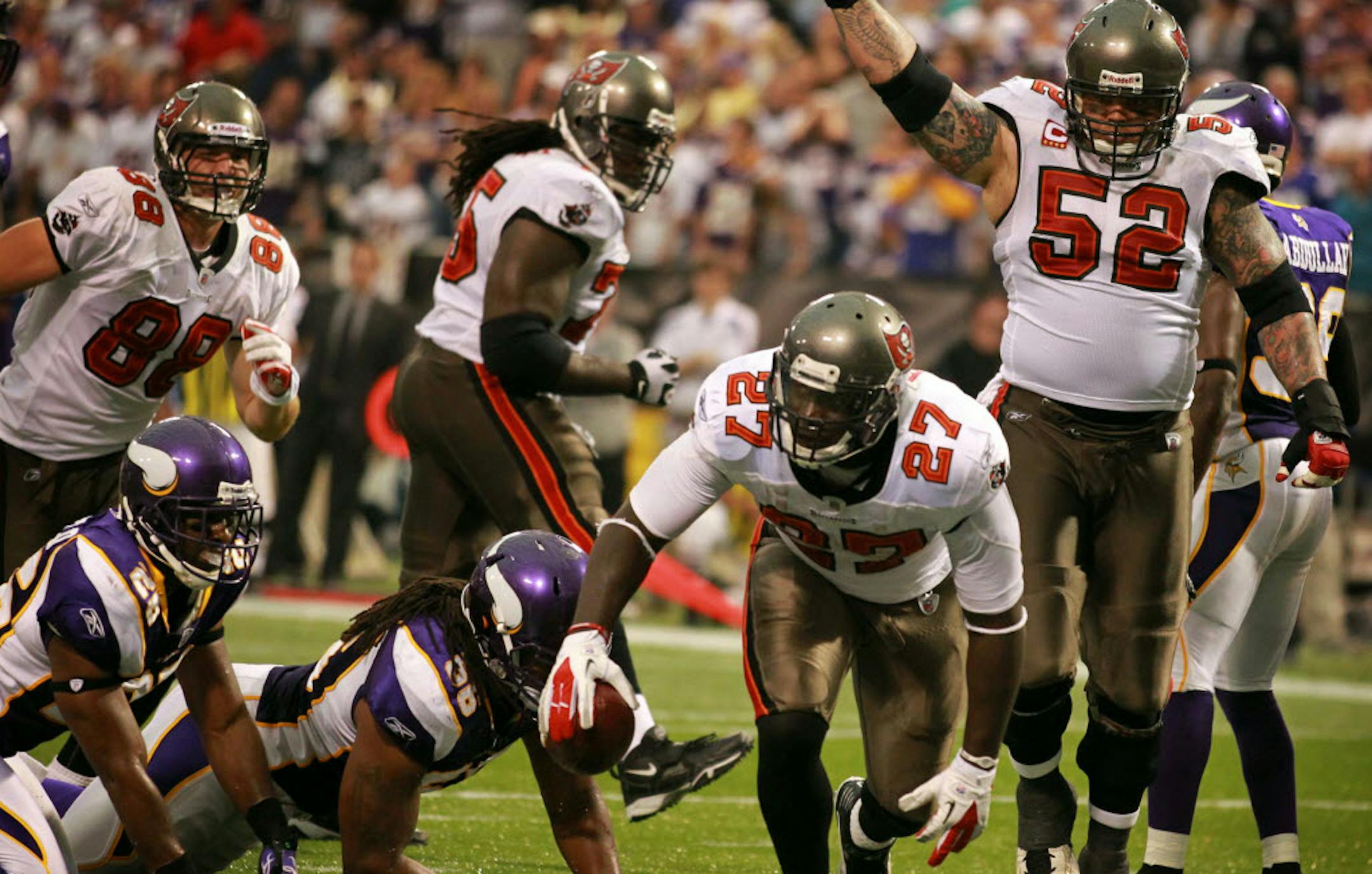 Antoine Winfield, left and E.J. Henderson couldn't keep Tampa Bay running back LeGarrette Blount out of the end zone in the final minute. Center Jeff Faine (52) celebrated Blount's winning 4-yard run.