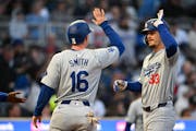 The Dodgers' James Outman high-fives with teammate Will Smith after Outman’s three-run homer in the fourth inning against the Twins at Target Field 