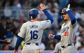 The Dodgers' James Outman high-fives with teammate Will Smith after Outman’s three-run homer in the fourth inning against the Twins at Target Field 