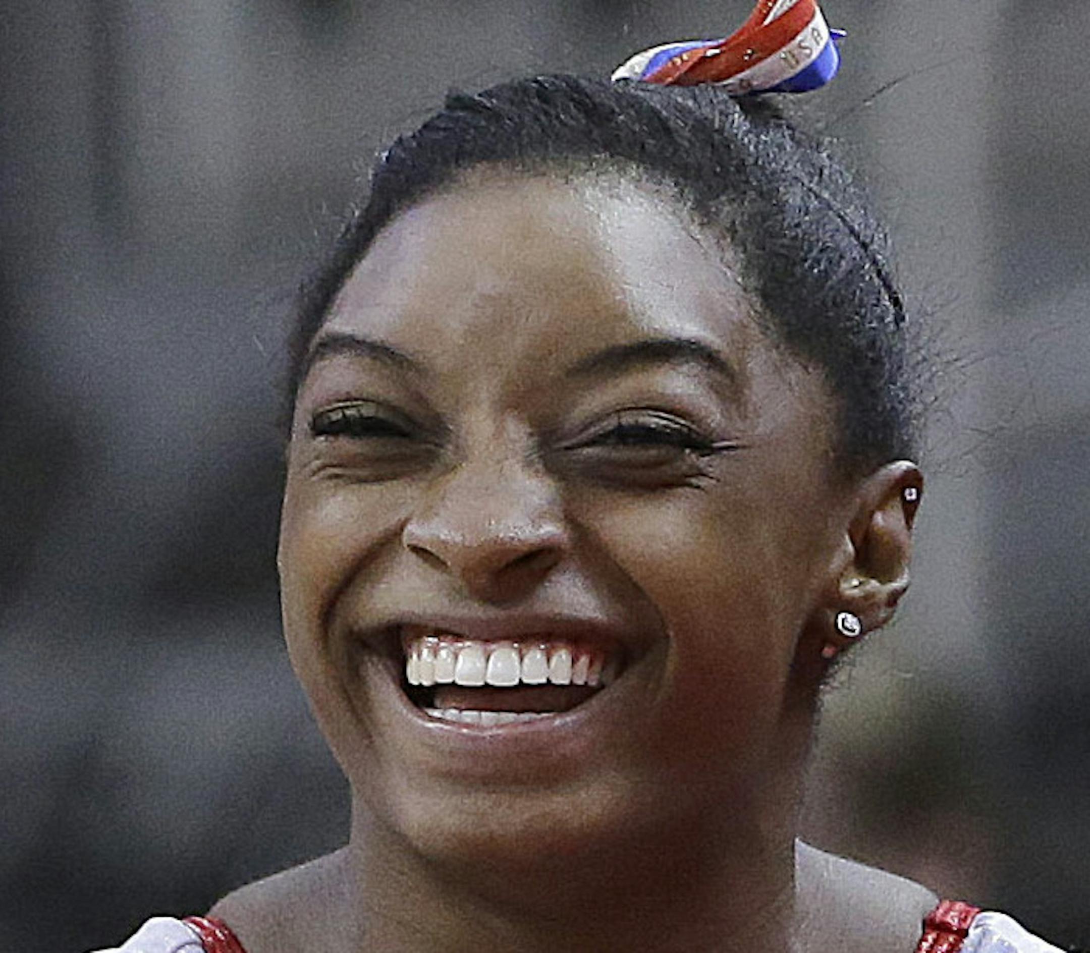 Simone Biles, left, smiles next to Gabrielle Douglas while stretching during practice at the U.S. Olympic trials in gymnastics in San Jose, Calif., Thursday, July 7, 2016. (AP Photo/Jeff Chiu)