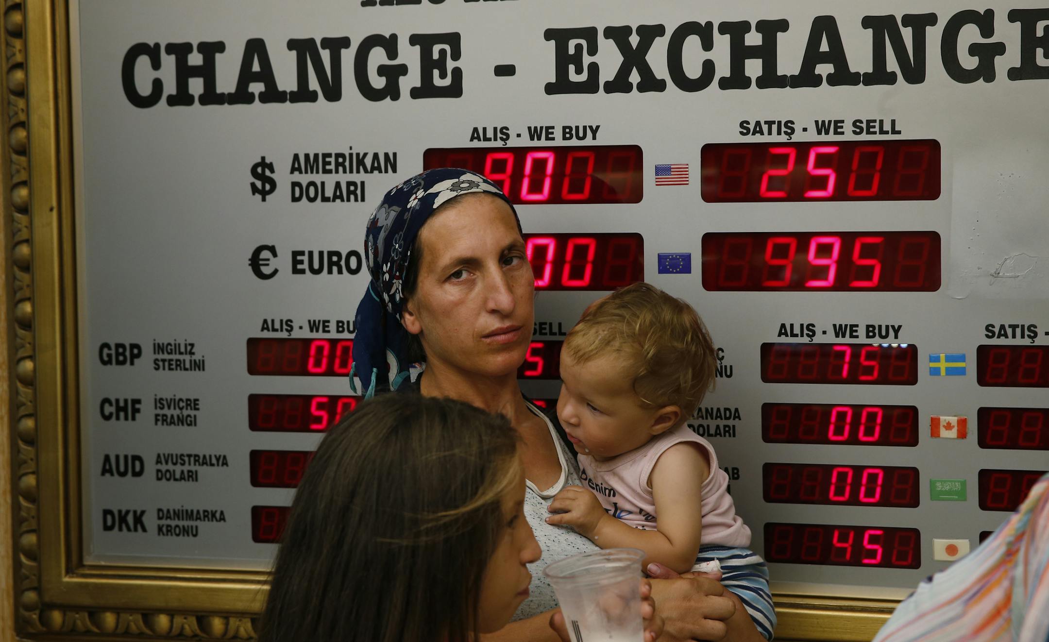 People wait at a currency exchange shop in Istanbul, Wednesday, Aug. 15, 2018. The Turkish lira has nosedived in value in the past week, but some Turks are reacting with defiance to their plunging currency and an escalating trade and political dispute with the United States. (AP Photo/Lefteris Pitarakis) ORG XMIT: AXLP201