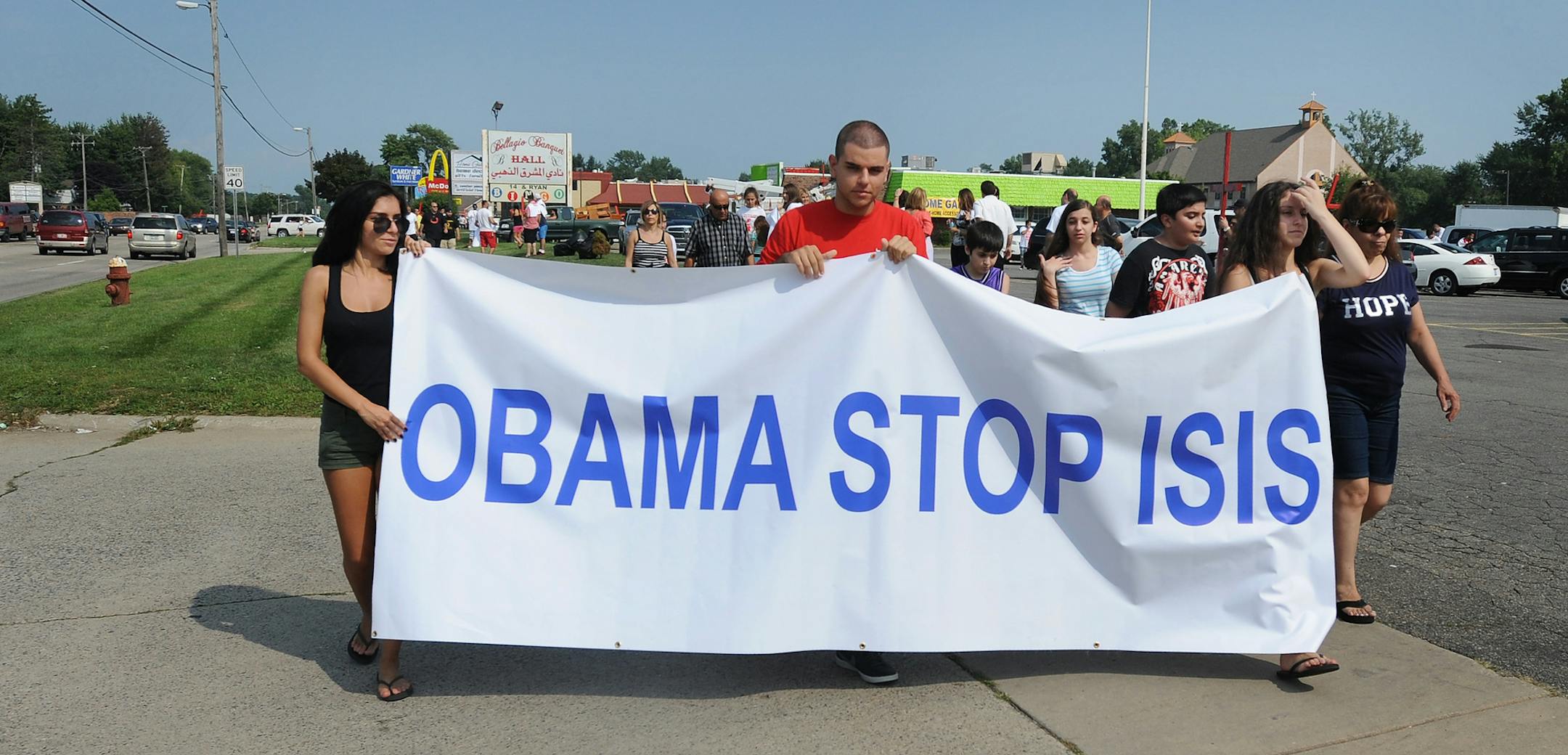 Protestors call on President Barack Obama to help end the bloodshed of Iraqi Christians as hundreds demonstrate against the terrorist group ISIS in Sterling Heights, Michigan on Sunday, Aug.10, 2014. (AP Photo/Detroit News, Brandy Baker)