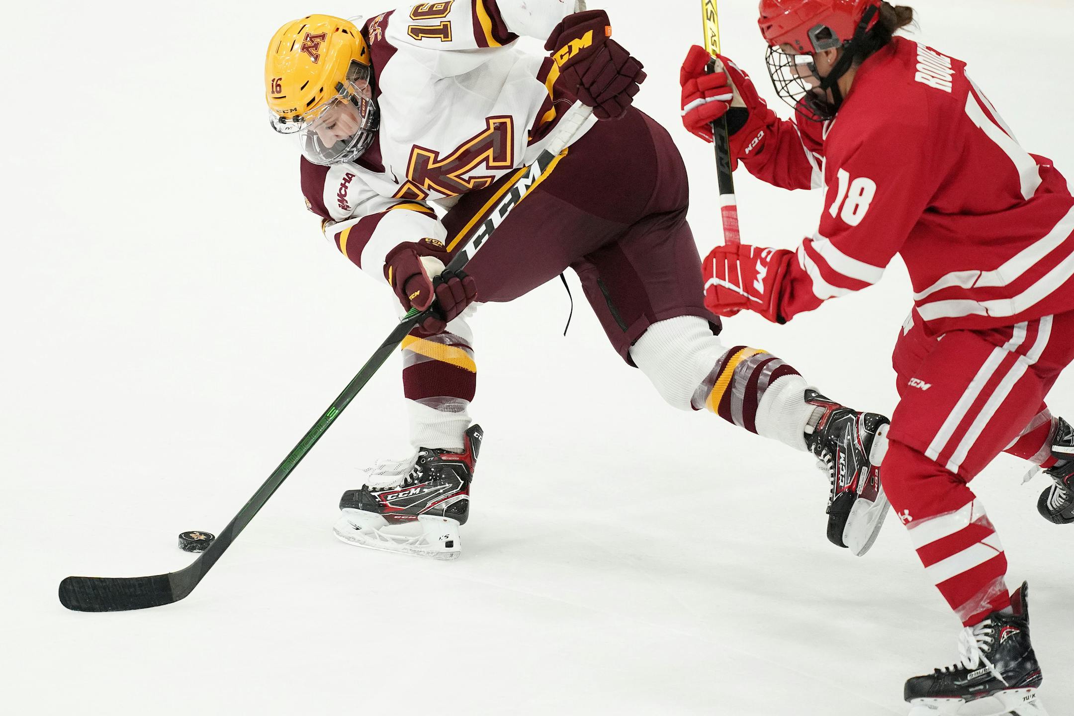 Gophers forward Amy Potomak got tripped up as she tried to keep the puck from Wisconsin forward Abby Roque on Saturday.