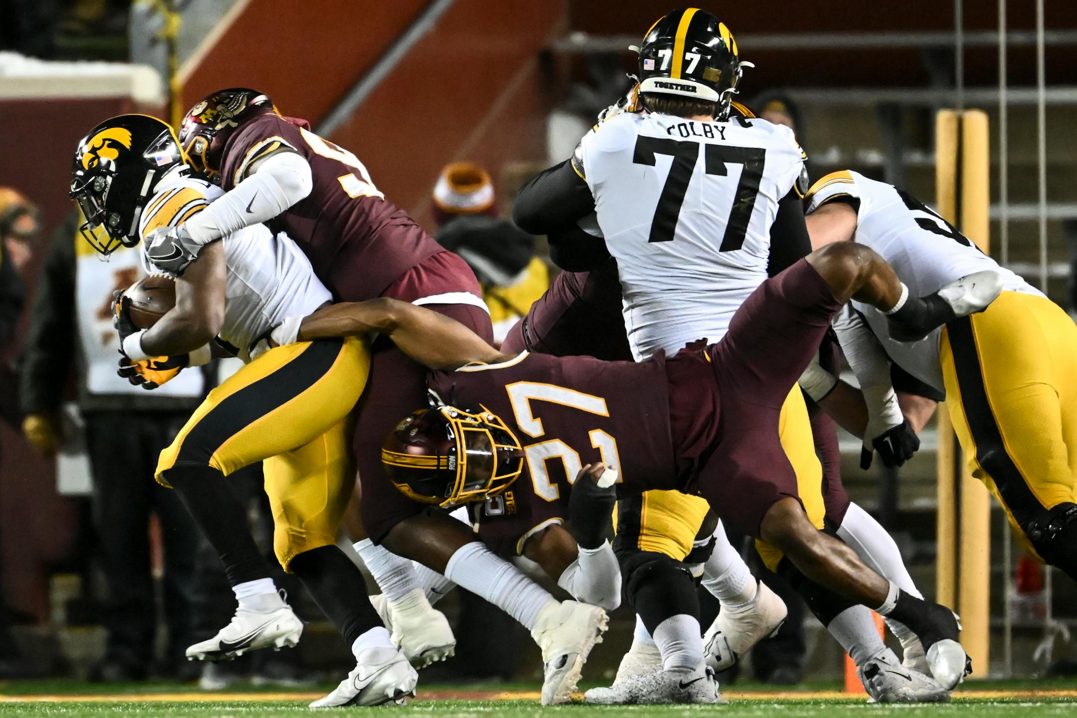 Minnesota Gophers players, including defensive back Tyler Nubin (27), struggle to tackle Iowa Hawkeyes running back Leshon Williams (4) during the fourth quarter.