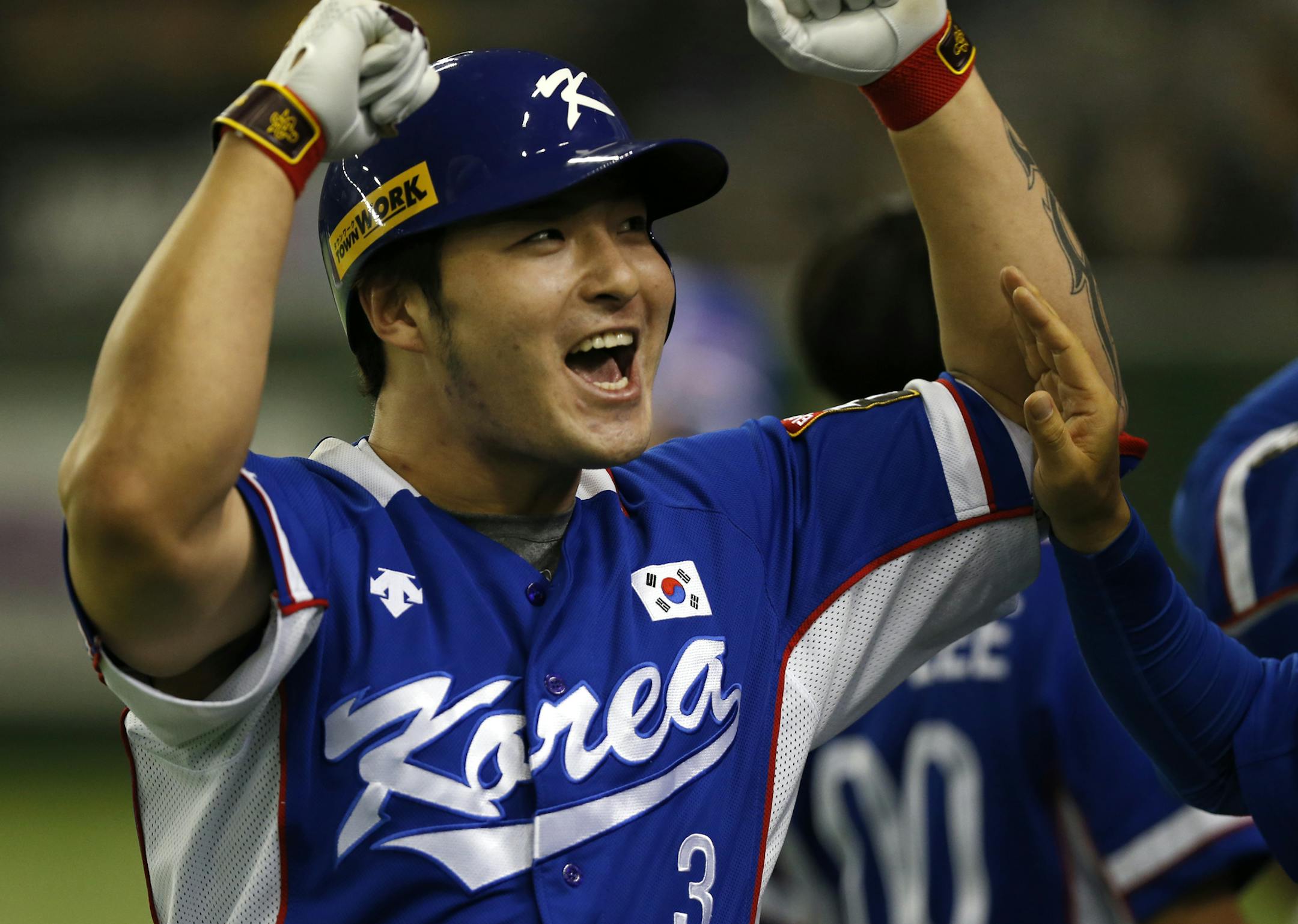 South Korea's Park Byung-ho celebrates at the bench after hitting a three-run home run against Team USA in the fourth inning of their final game at the Premier12 world baseball tournament at Tokyo Dome in Tokyo, Saturday, Nov. 21, 2015. (AP Photo/Toru Takahashi)