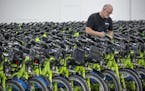 Sean Davis of Nice Ride took tags off bikes as the company rolled out its fleet throughout Minneapolis in April. Next year Nice Ride will add 2,000 e-