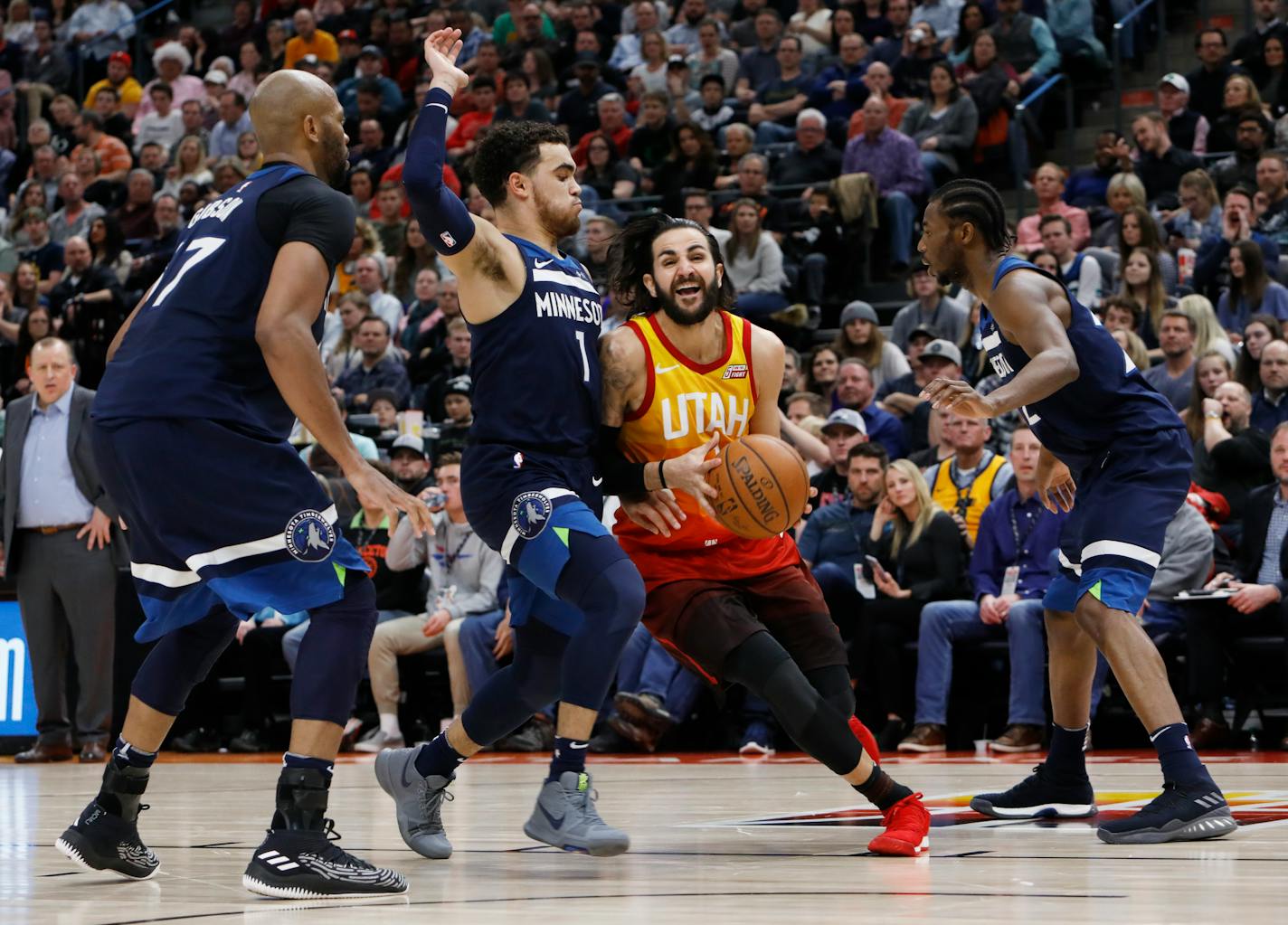 Utah Jazz's Ricky Rubio, middle, drives the basket as Minnesota Timberwolves' Tyus Jones (1) defends during the second half of an NBA basketball game on Friday, March 2, 2018, in Salt Lake City. The Jazz went on to win 116-108.