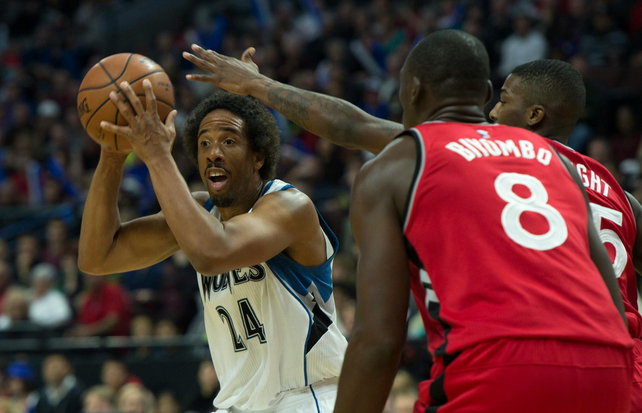 Minnesota Timberwolves guard Andre Miller looks to pass the ball under pressure from Toronto Raptors guard Delon Wright and forward Bismack Biyombo during first half of an NBA preseason basketball game, Wednesday, Oct. 14, 2015 in Ottawa. (Adrian Wyld/The Canadian Press via AP) MANDATORY CREDIT
