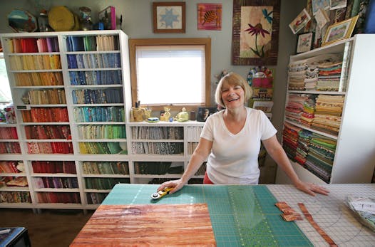 Jackie Olmstead’s quilting room features colorful displays of her materials, plus all the spaces she needs to create quilts.