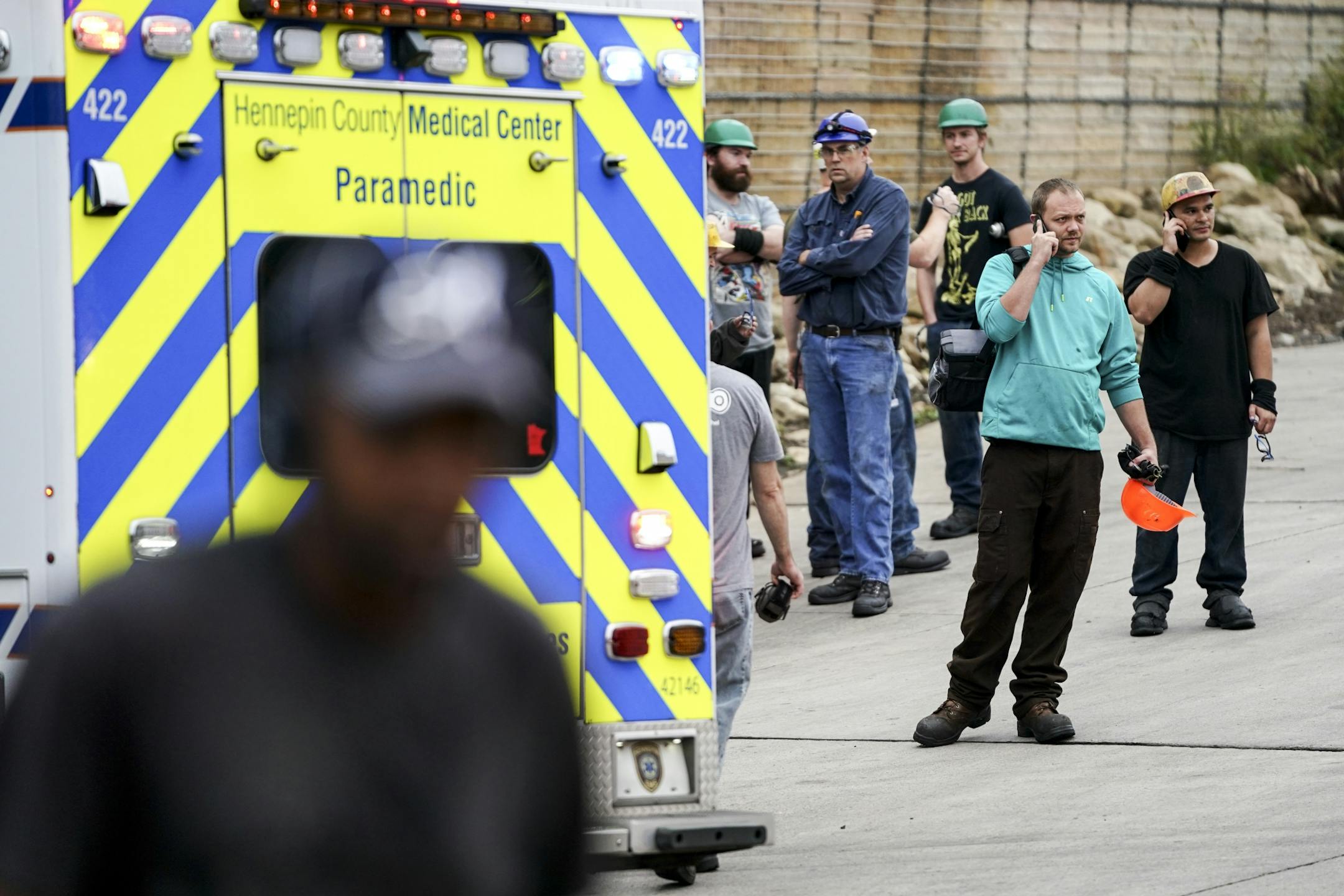 Workers waited by an ambulance after a fire and explosion which resulted in two serious injuries at Metal-Matic in Minneapolis.