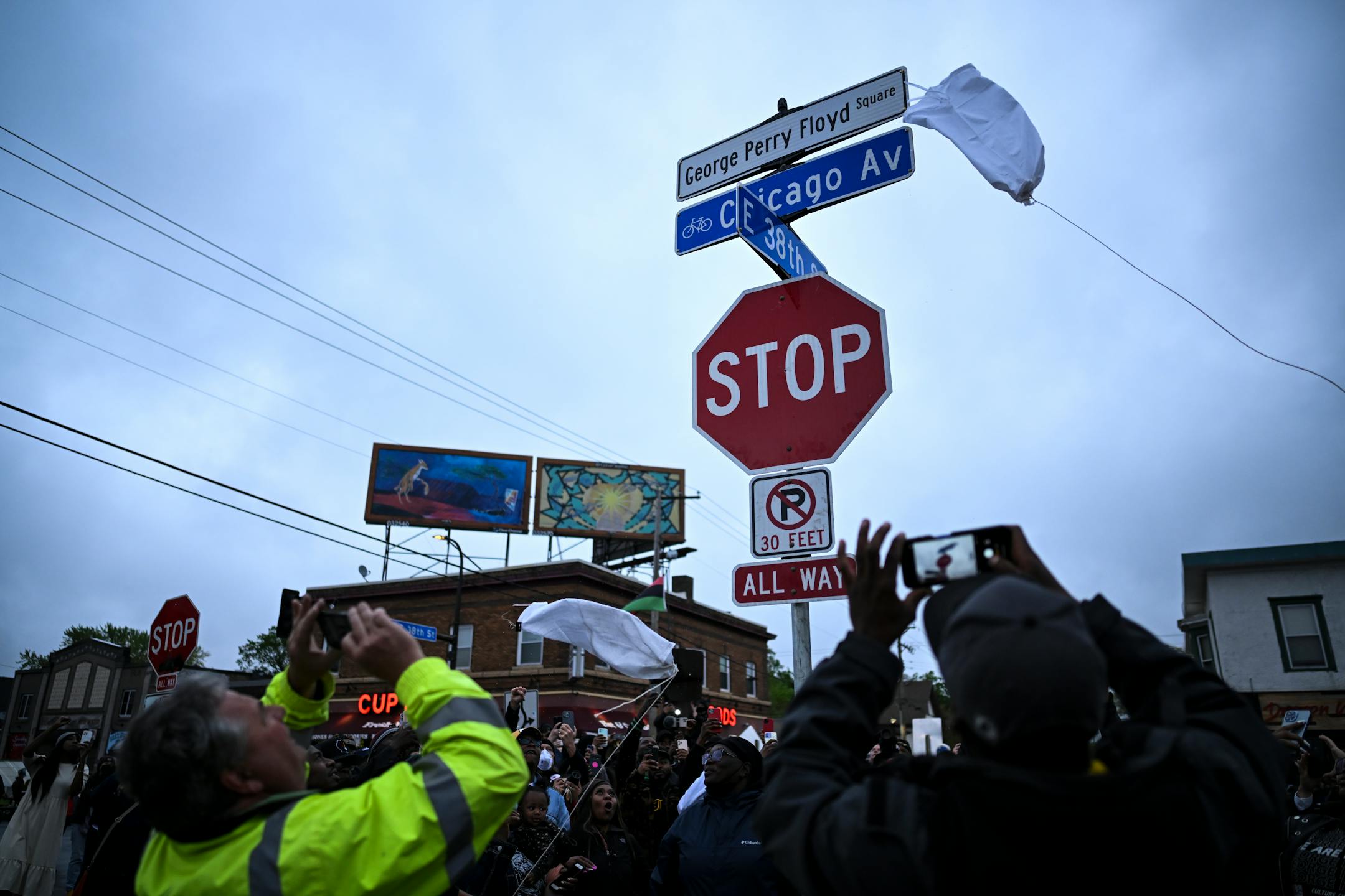 A new 'George Perry Floyd Square' sign is unveiled in front of hundreds of community members.