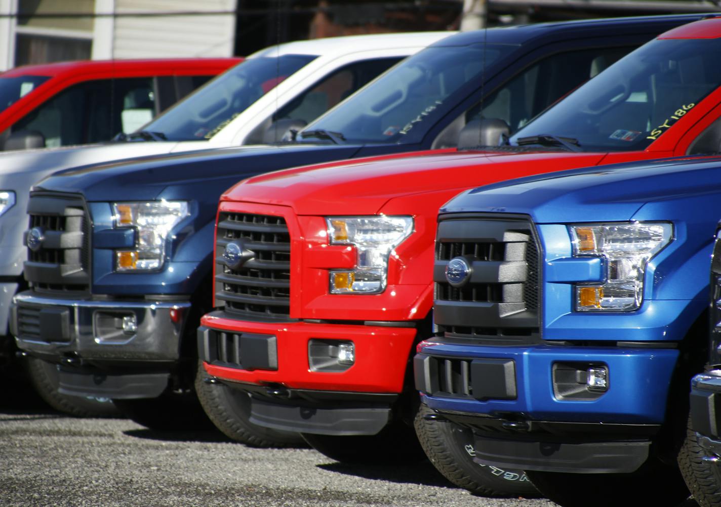 In this photo made on Thursday, Nov. 19, 2015, a row of 2015 Ford F-150 pickup trucks are parked on the sales lot at Butler County Ford in Butler, Pa. Two auto sales forecasting companies say Americans will buy more cars and trucks in December 2015 than any other month in more than a decade. LMC Automotive and J.D. Power are predicting that U.S. sales will hit 1.71 million this month, the highest number since sales reached 1.8 million in July of 2005. (AP Photo/Keith Srakocic)