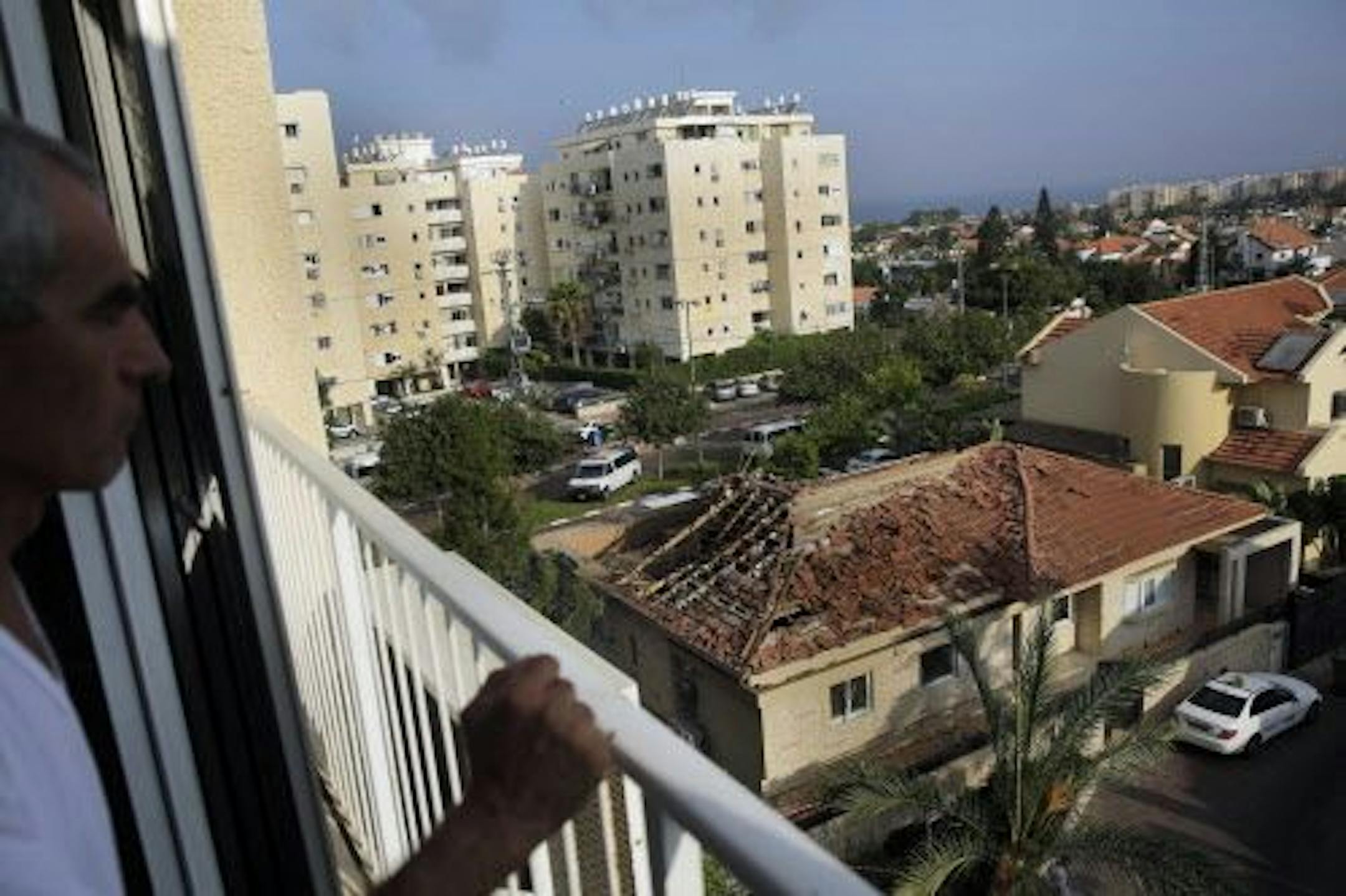 A man looks at a home hit by a rocket fired from the northern Gaza Strip Tuesday morning in the costal city of Ashkelon, Israel, Tuesday, Aug. 26, 2014.
