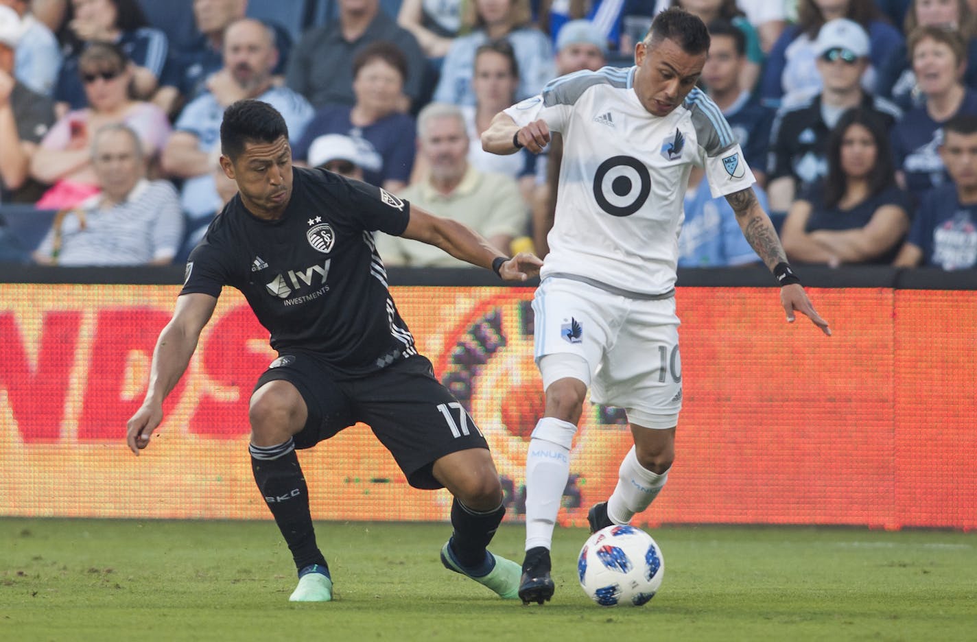 Minnesota United FC midfielder Miguel Ibarra (10) shields off Sporting Kansas City midfielder Roger Espinoza (17) during the match between Sporting Kansas City and Minnesota United FC on Sunday June 3, 2018 at Children's Mercy Park in Kansas City, KS. Nick Tre. Smith/Special to the Star. ORG XMIT: B7312413200Z.1