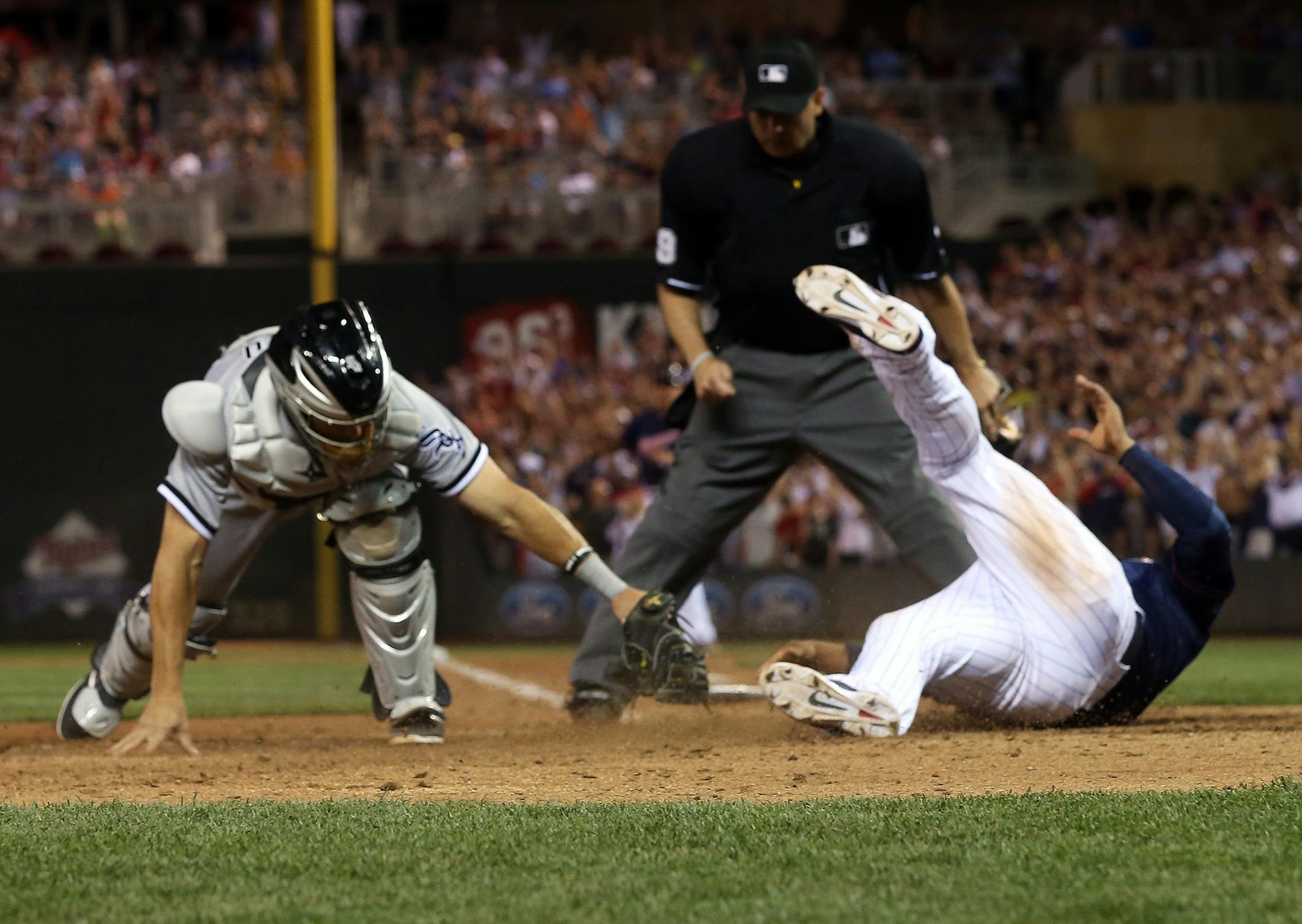 Minnesota Twins' Eduardo Escobar, right, beats the tag by Chicago White Sox catcher Adrian Nieto to score the winning run on a walk off single by Brian Dozier in a baseball game, Friday, June 20, 2014, in Minneapolis. The Twins won 5-4. (AP Photo/Jim Mone)