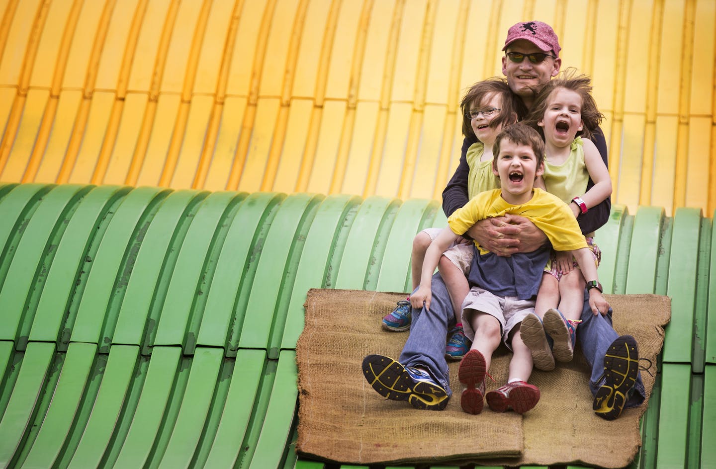 Dan Huse of Woodbury rides the giant slide with his son Calvin, 6, and twin four-year-old daughters Hana, left, and Lexi at the Minnesota State Fair on Friday, August 28, 2015.