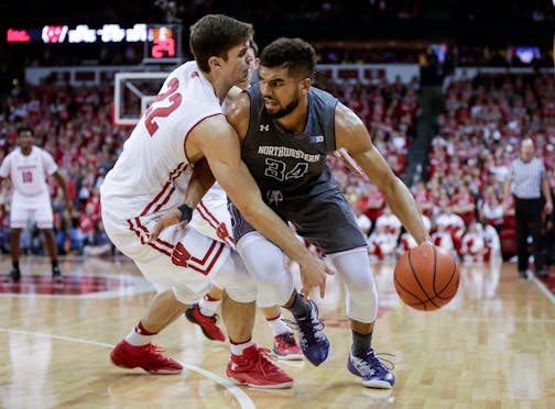 Wisconsin's Ethan Happ, left, fouls Northwestern's Sanjay Lumpkin (34) during the second half of an NCAA college basketball game, Sunday, Feb. 12, 2017, in Madison, Wis. Northwestern upset Wisconsin 66-59. (AP Photo/Andy Manis)