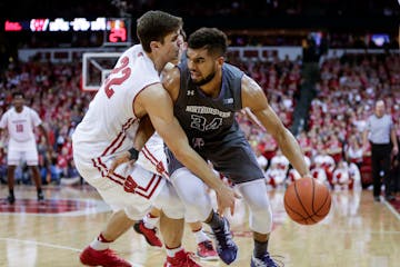 Wisconsin's Ethan Happ, left, fouls Northwestern's Sanjay Lumpkin (34) during the second half of an NCAA college basketball game, Sunday, Feb. 12, 201