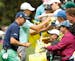 Justin Thomas and Jordan Spieth sign autographs during the par three competition at the Masters on Wednesday