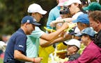 Justin Thomas and Jordan Spieth sign autographs during the par three competition at the Masters on Wednesday