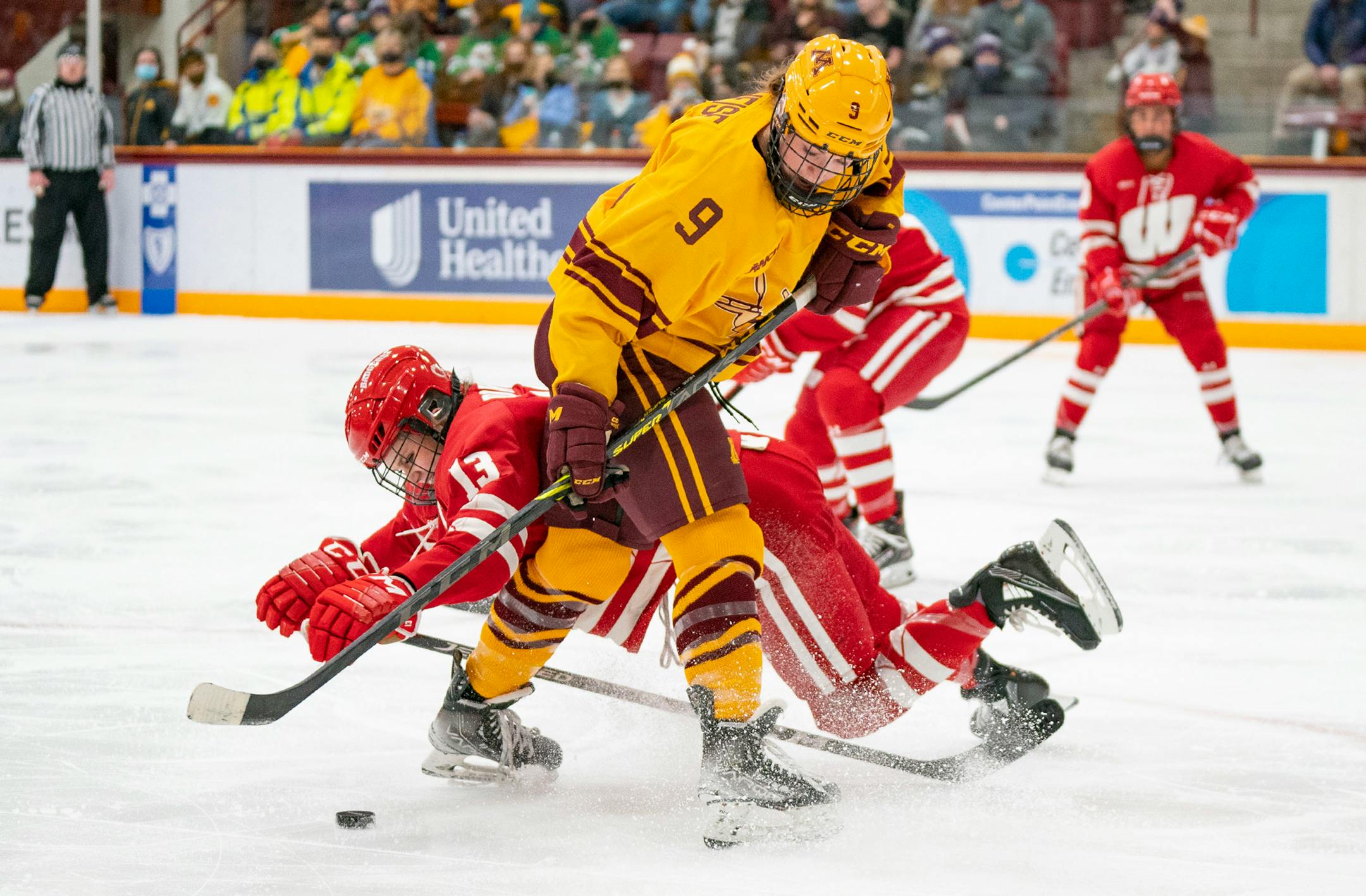 Minnesota forward Taylor Heise (9) keeps the puck away from Wisconsin defenseman Grace Bowlby (13) in the third period Saturday, Jan. 22, 2022 in Ridder Arena in Minneapolis, Minn. ]