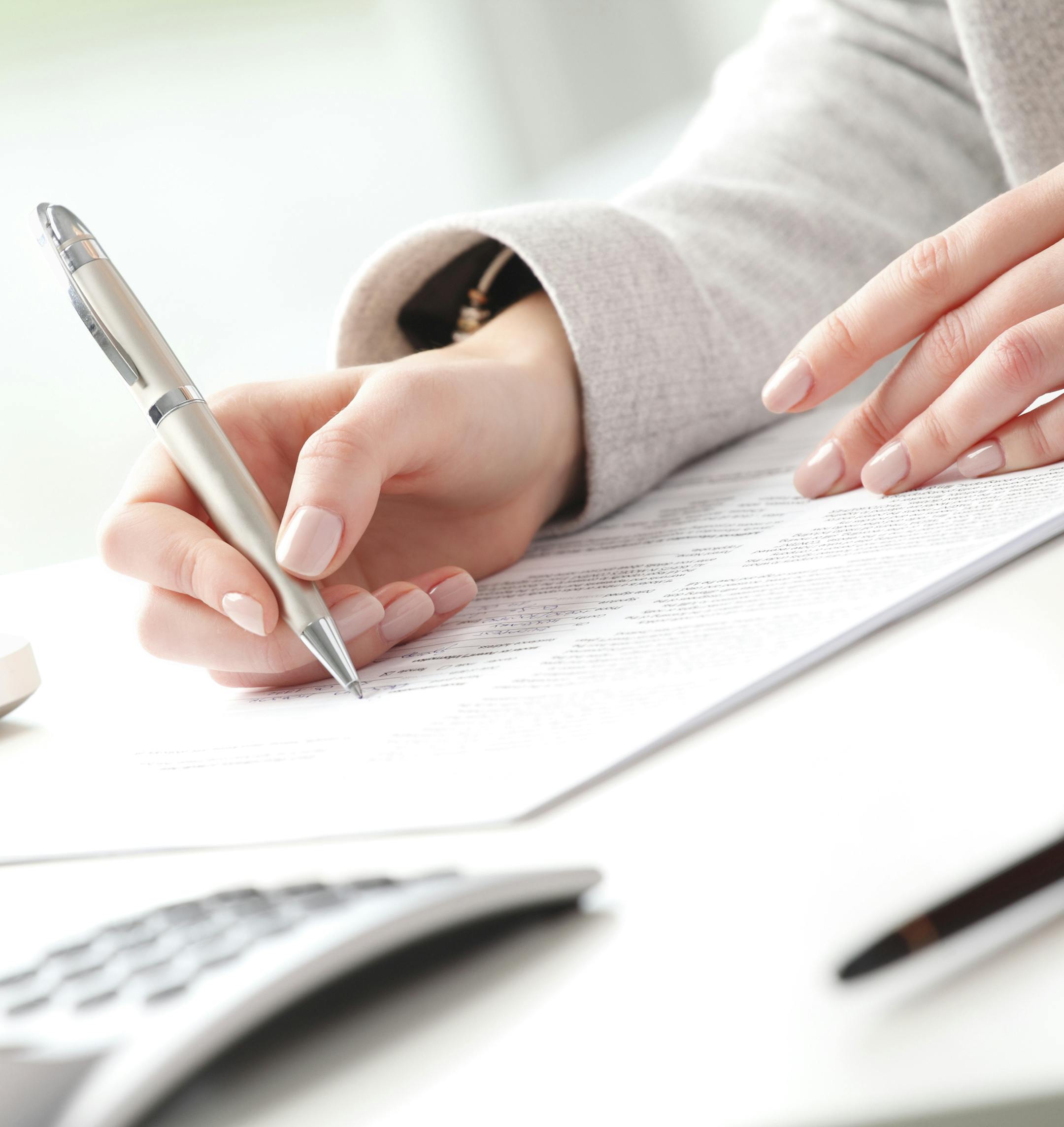 Businesswoman sitting at desk and fill the form. istock