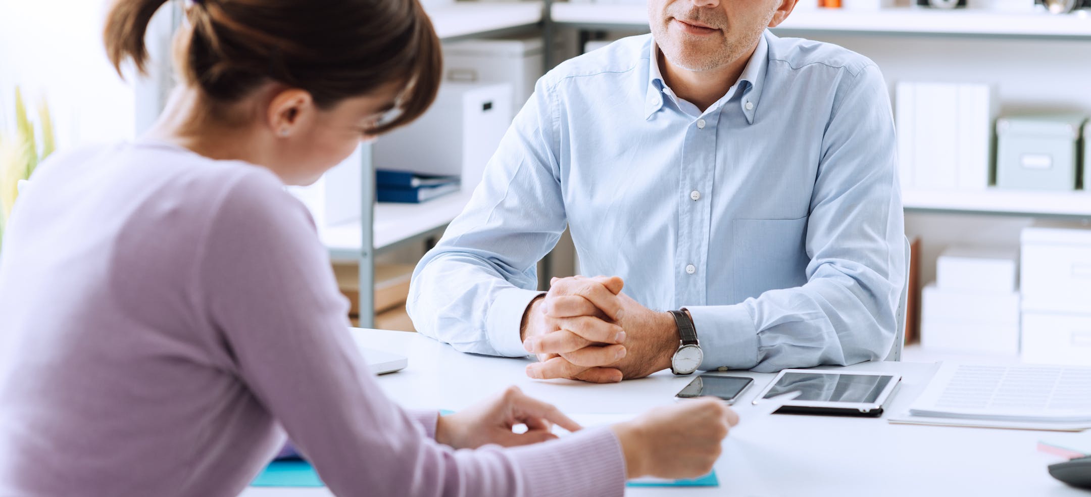 Mature businessman and young woman having a business meeting in the office, they are discussing together