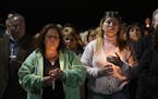Maria Busch ,left, and Tammy Smith both of Amsterdam, N.Y., gather with family and friends for a candlelight vigil memorial at Mohawk Valley Gateway O