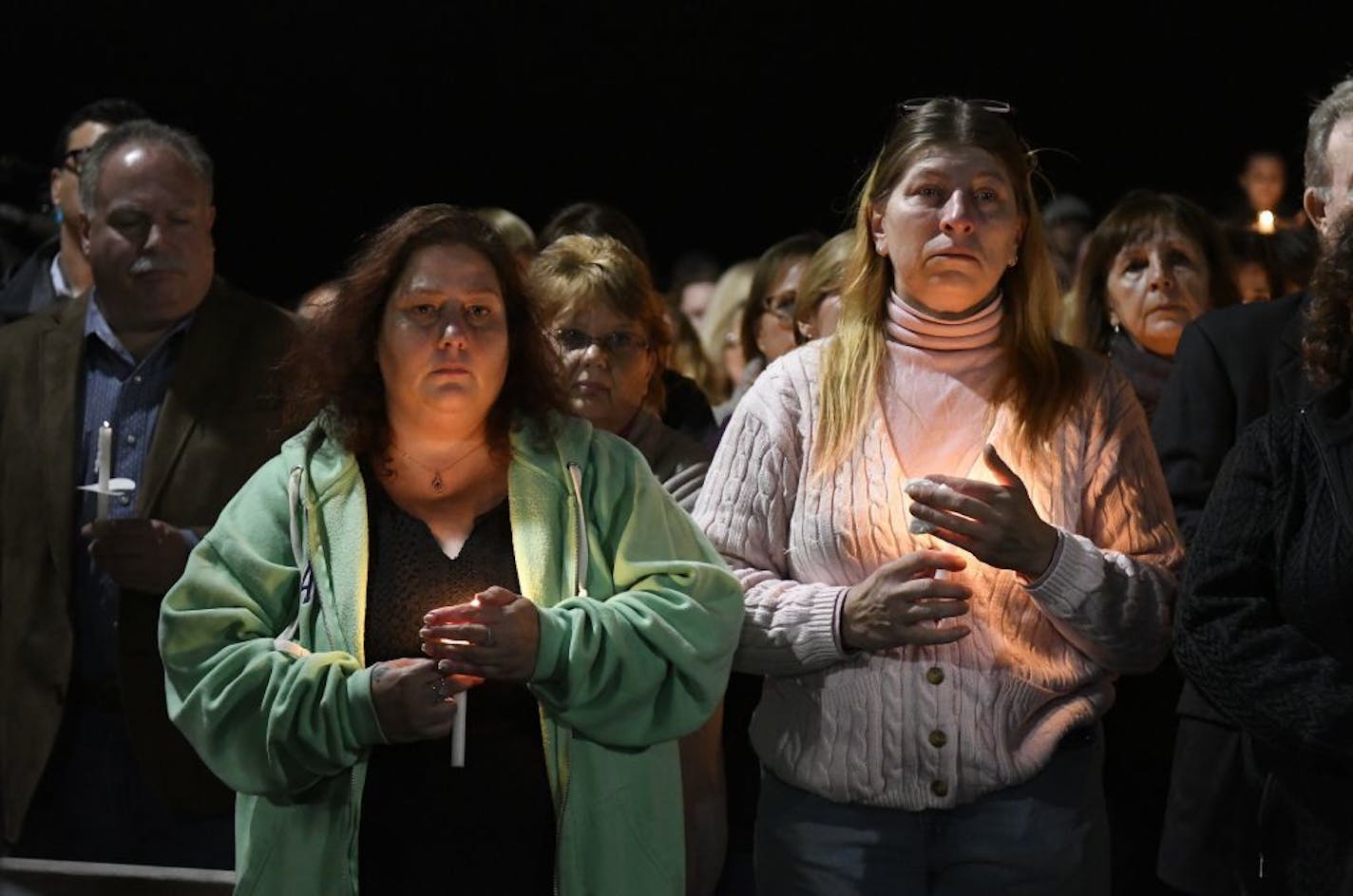 Maria Busch ,left, and Tammy Smith both of Amsterdam, N.Y., gather with family and friends for a candlelight vigil memorial at Mohawk Valley Gateway Overlook Pedestrian Bridge in Amsterdam, N.Y., Monday, Oct. 8, 2018. The memorial honored 20 people who died in Saturday's fatal limousine crash in Schoharie, N.Y.,