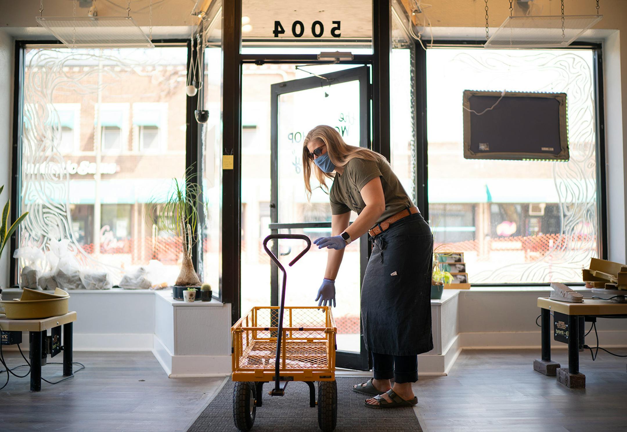 Jennie Tang returned her hauling wagon to its spot after helping a customer with a load of clay to her car. When Minneapolis launched its forgivable loan program to help small businesses cope with the pandemic, it put in place criteria that made businesses in large swaths of the city ineligible. Jennie Tang, owner of The Workshop Minneapolis, a pottery studio in south Minneapolis applied for the program but later learned her business wasn't eligible because of its location. She worked in her sho