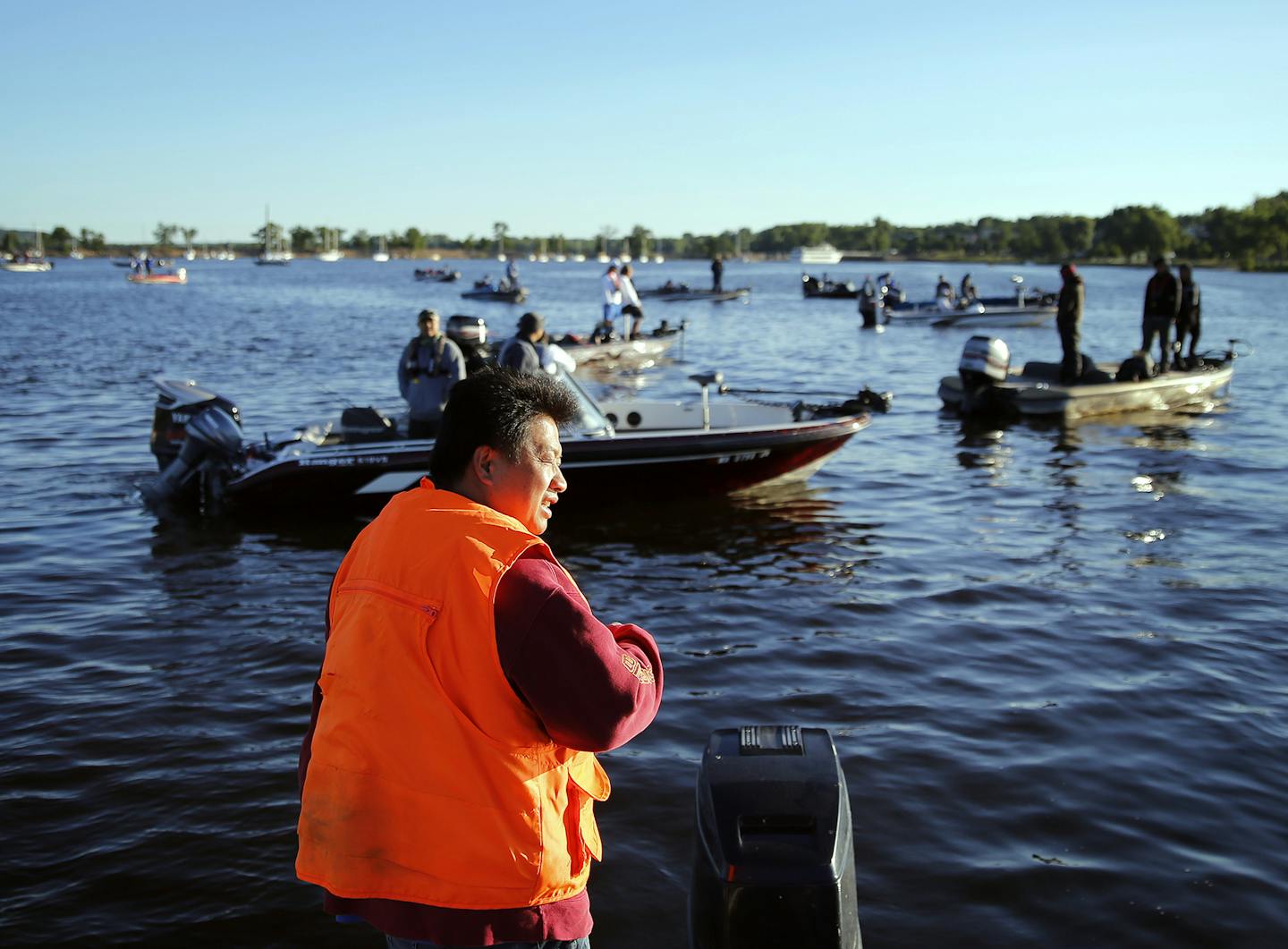 Danny Thao calls out numbers of boats during the early morning launch from Lakefront Park in Hudson, Wis.