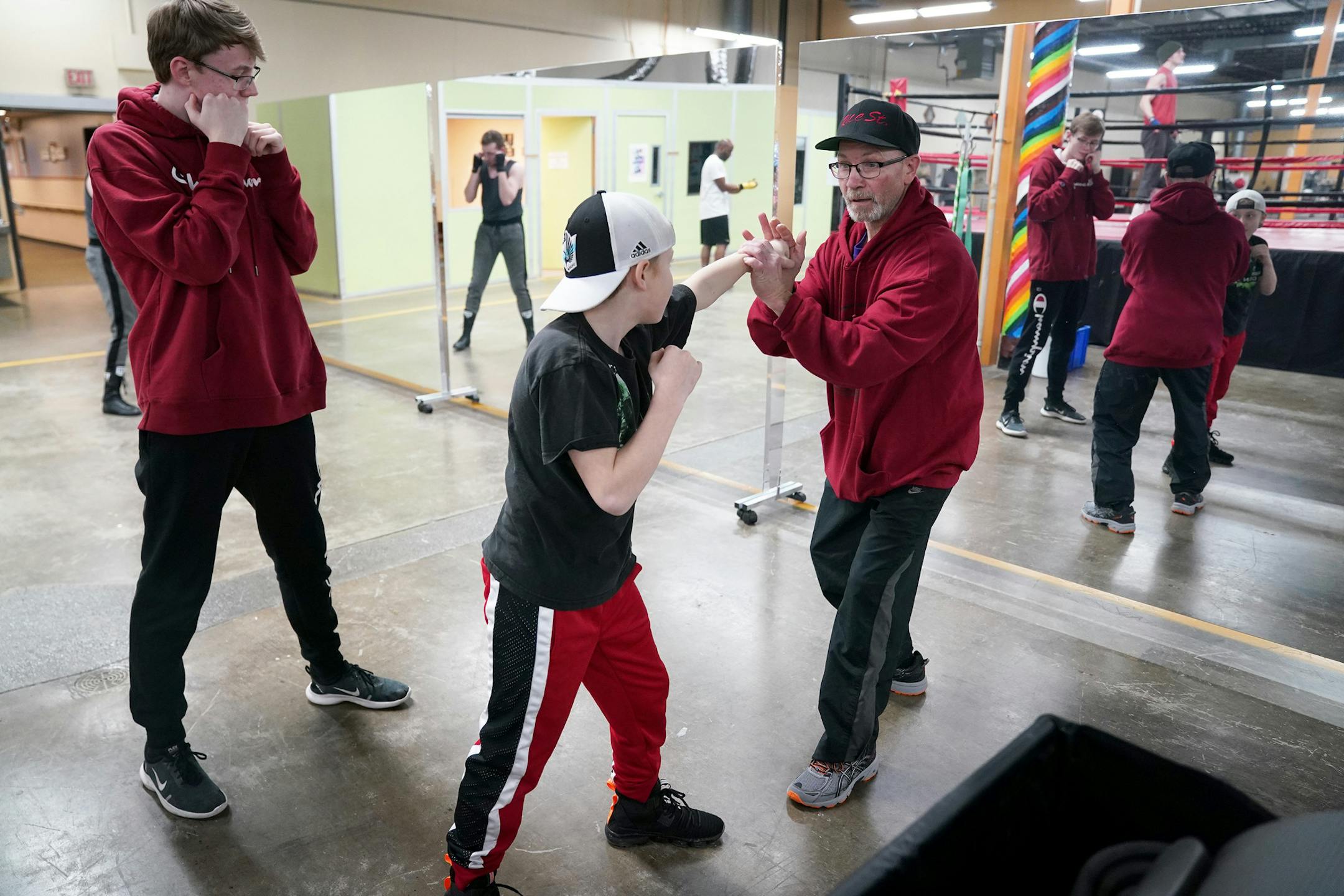 Mike Evgen explained technique to Soren Holdahl, 10, as he and Jake Kolb, 13, shadowboxed with a mirror. ] ANTHONY SOUFFLE • anthony.souffle@startribune.com Mike Evgen, the former Rice Street Rocker of area pro boxing fame, worked out with some of his fighters at his new boxing gym the Rice Street Old School Boxing Gym (though it's not on Rice Street) Thursday, Jan. 23, 2020 in St. Paul, Minn.